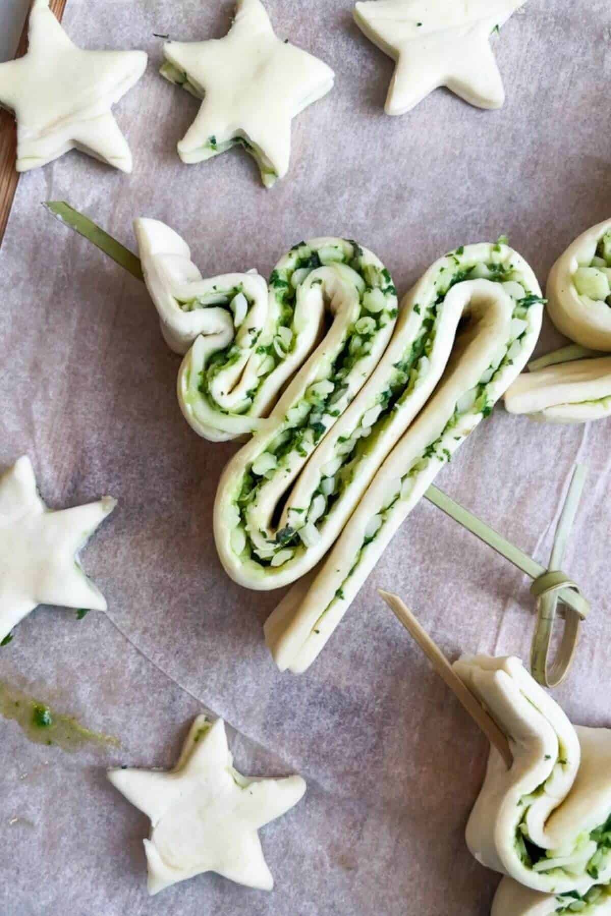 Close up of skewered puff pastry Christmas tree and stars on a lined oven tray.