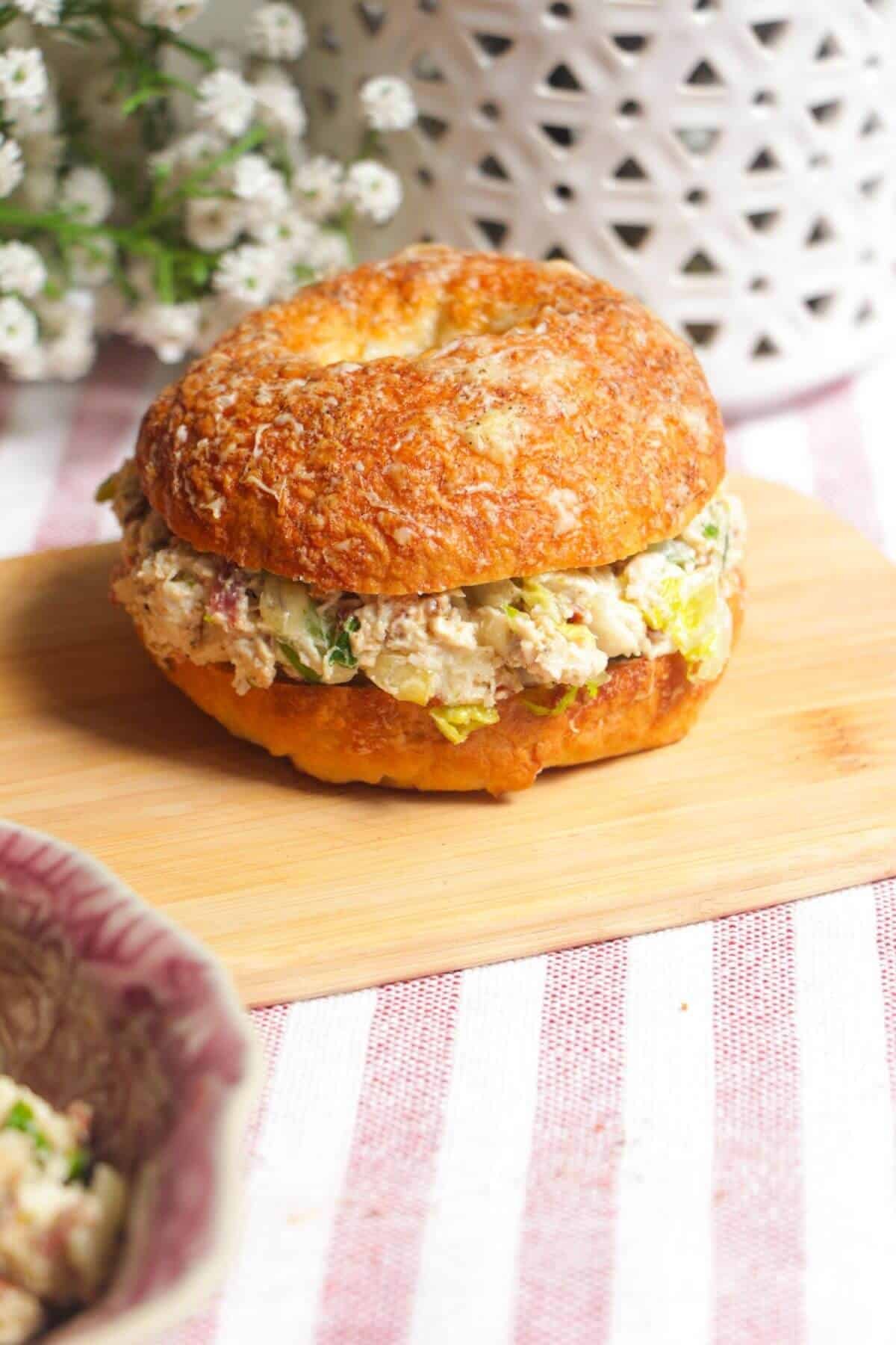 Chicken Caesar salad chopped bagel on a wooden board.