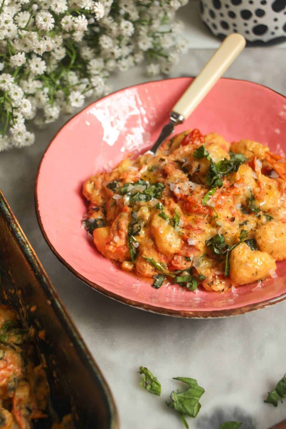 Creamy Boursin gnocchi in a pink bowl.