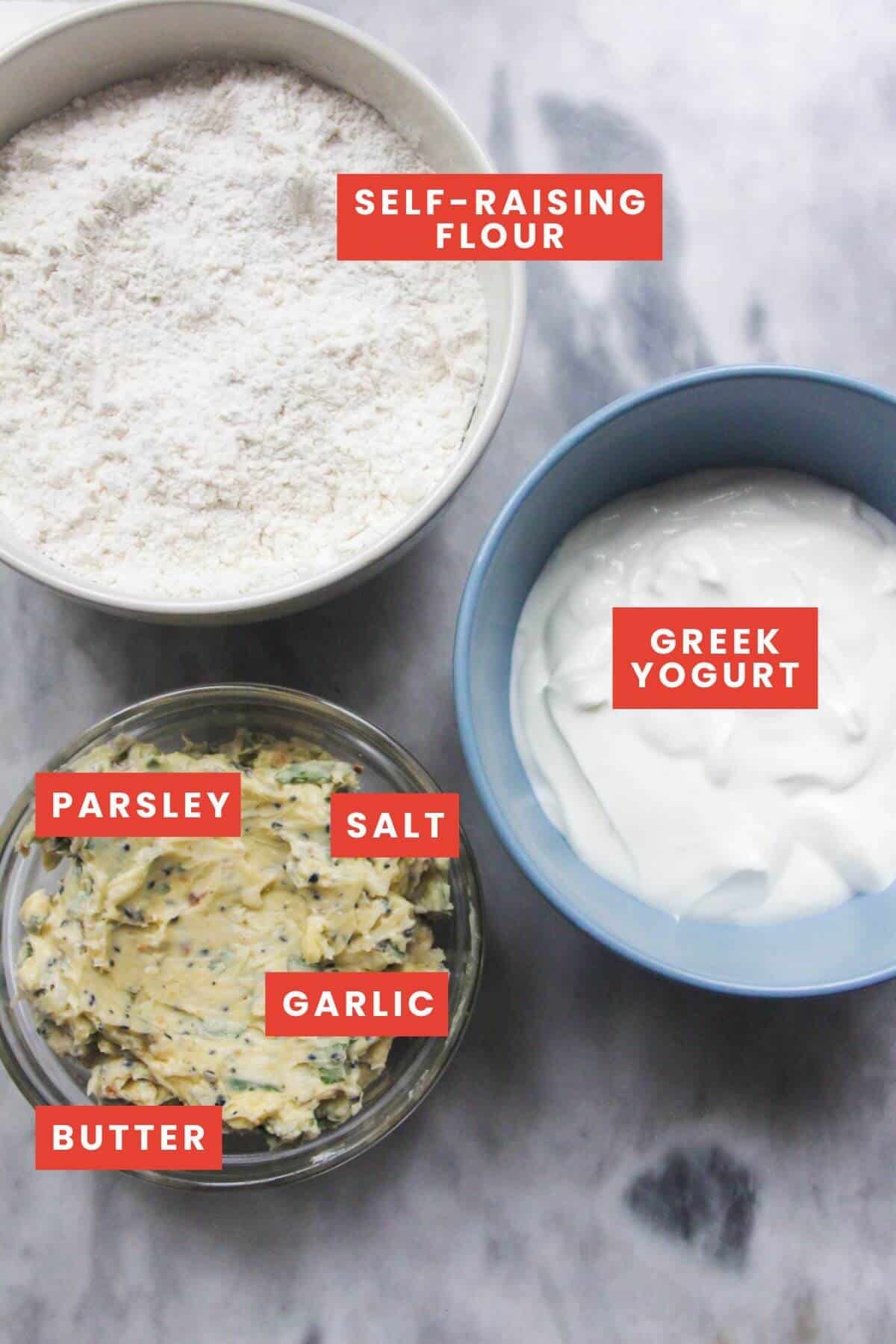 Ingredients for garlic naan laid out on a grey marble background and labelled.