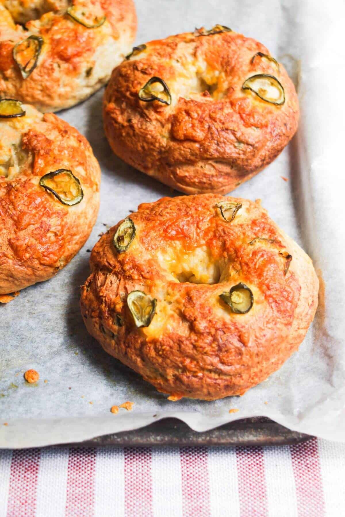 Cheese and jalapenos on top of bagels.