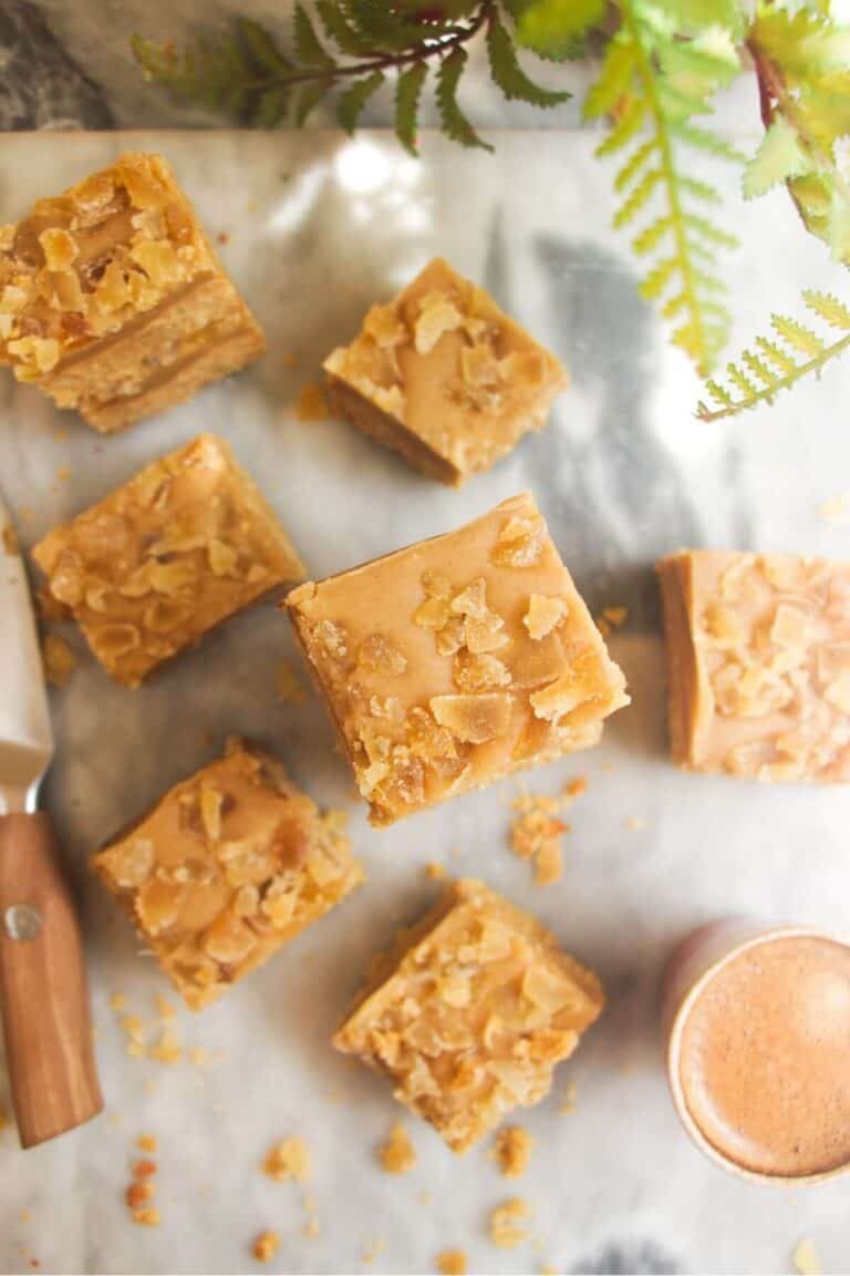 Pile of ginger crunch on top of each other with a coffee cup on the side.