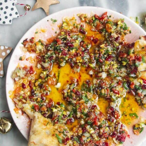 Festive dipping oil in a small pink plate on a grey surface.