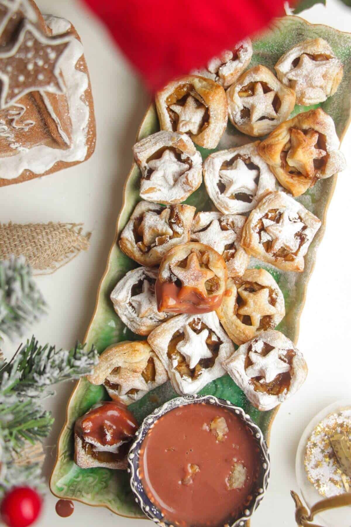 A platter of mini apple pie bites dusted with icing sugar.