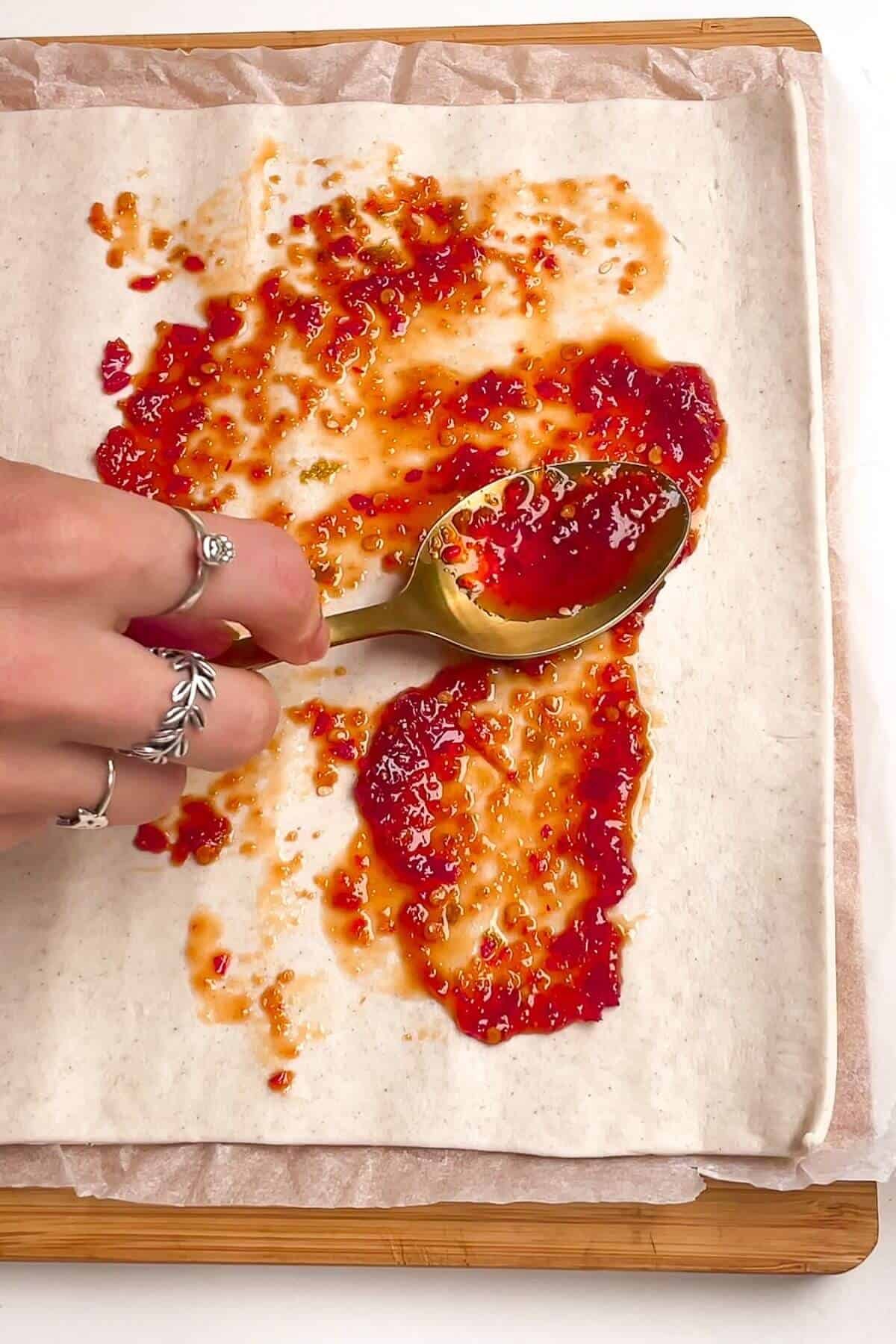 Spooning sweet chilli onto puff pastry.