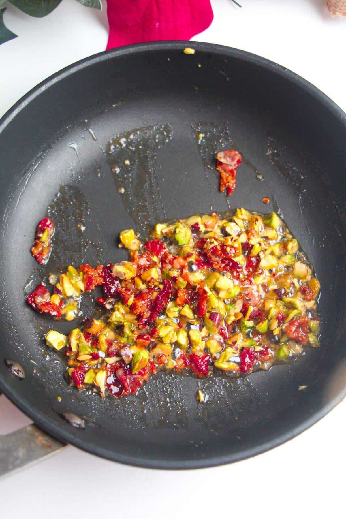 Bacon, pistachios in a small pan.
