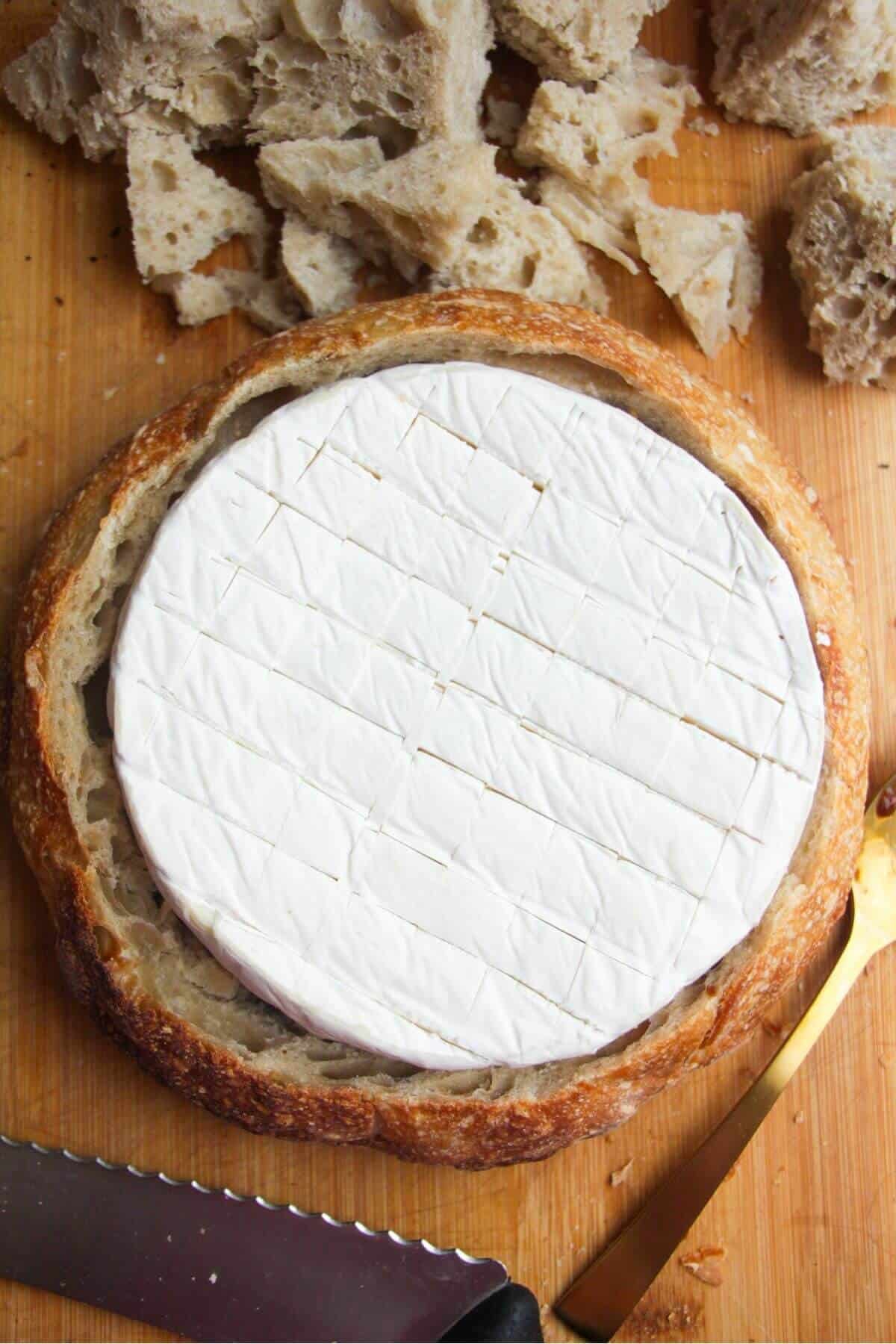 Large wheel of brie inside a loaf of bread.