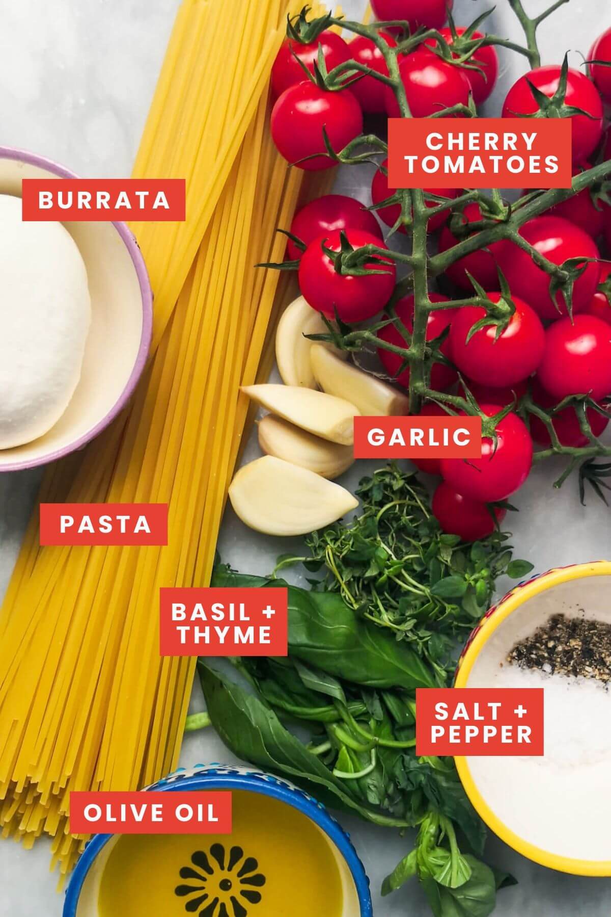 ingredients for burrata pasta laid out on a marble board, labelled.