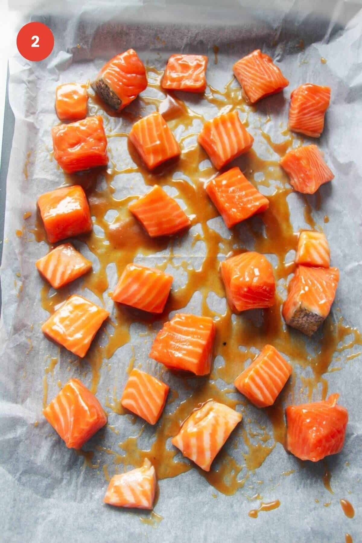 Diced salmon pieces tossed in honey miso marinade on sheet pan.