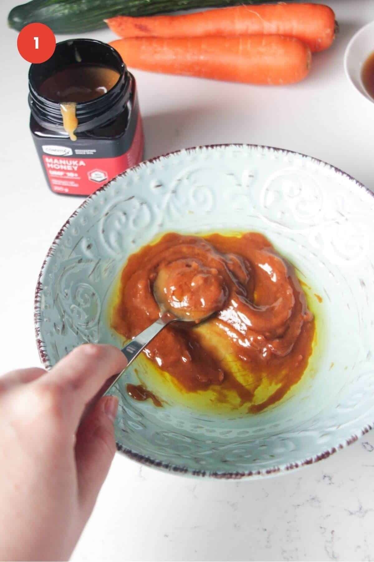 Mixing miso honey marinade with a spoon in a small bowl.