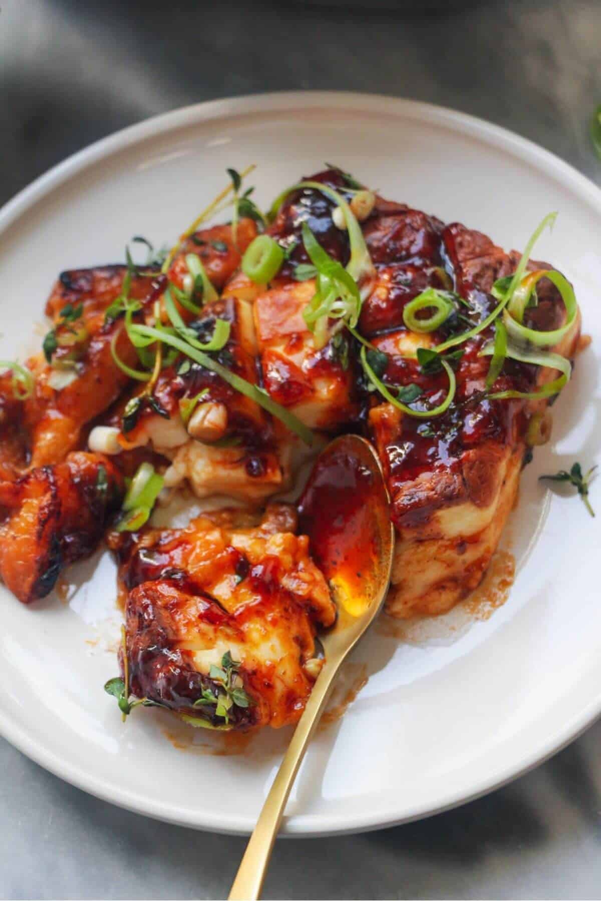 Close up of baked whole halloumi on a small white plate.