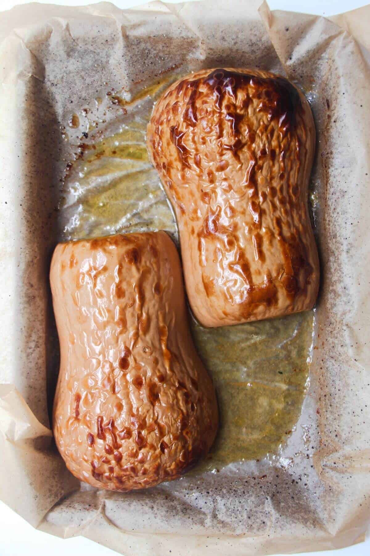 Roasted squash on a lined oven tray.