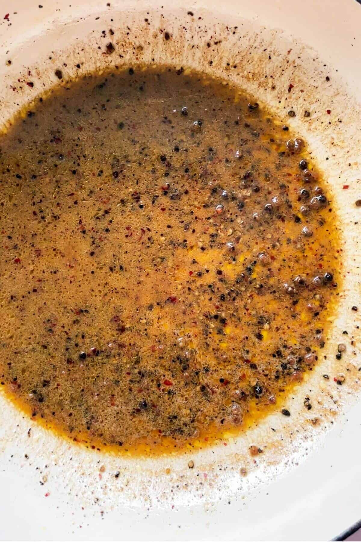 Pasta water, butter and black pepper in a pan.