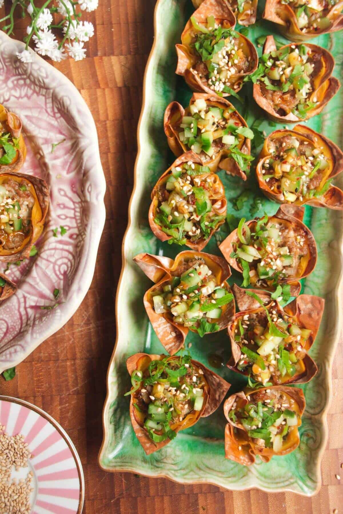 Mini dumpling cups on a green plate.
