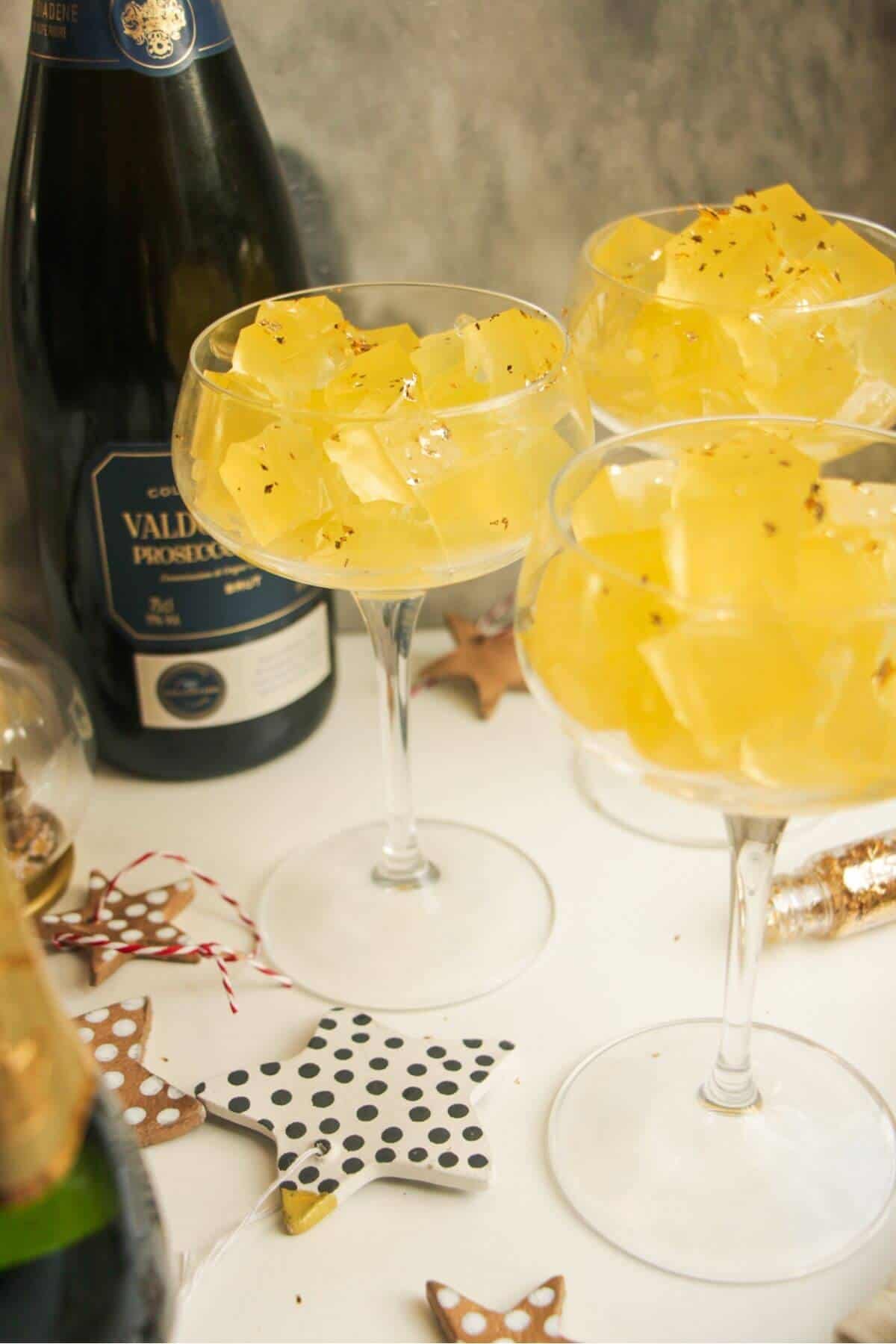 Three champagne coupes filled with jello cubes.