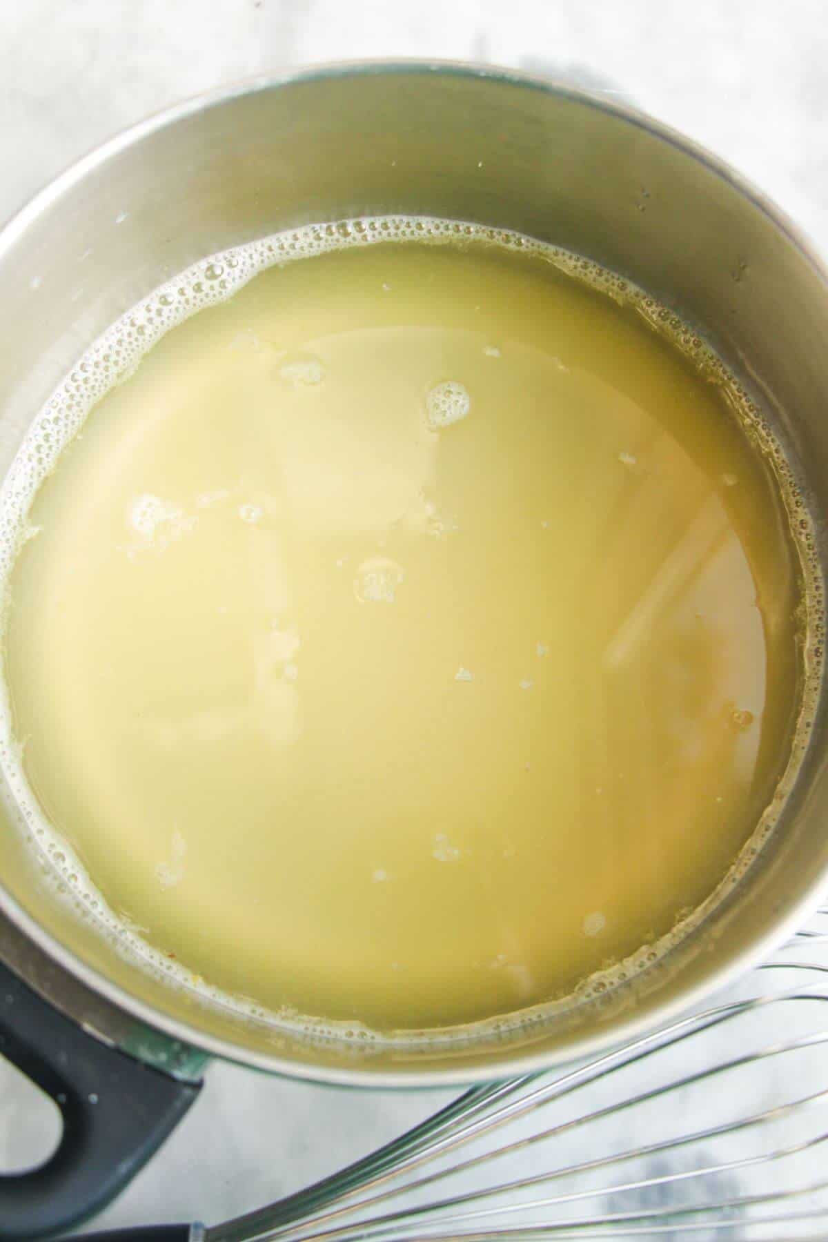 Prosecco, lemon juice and gin in a small pot.