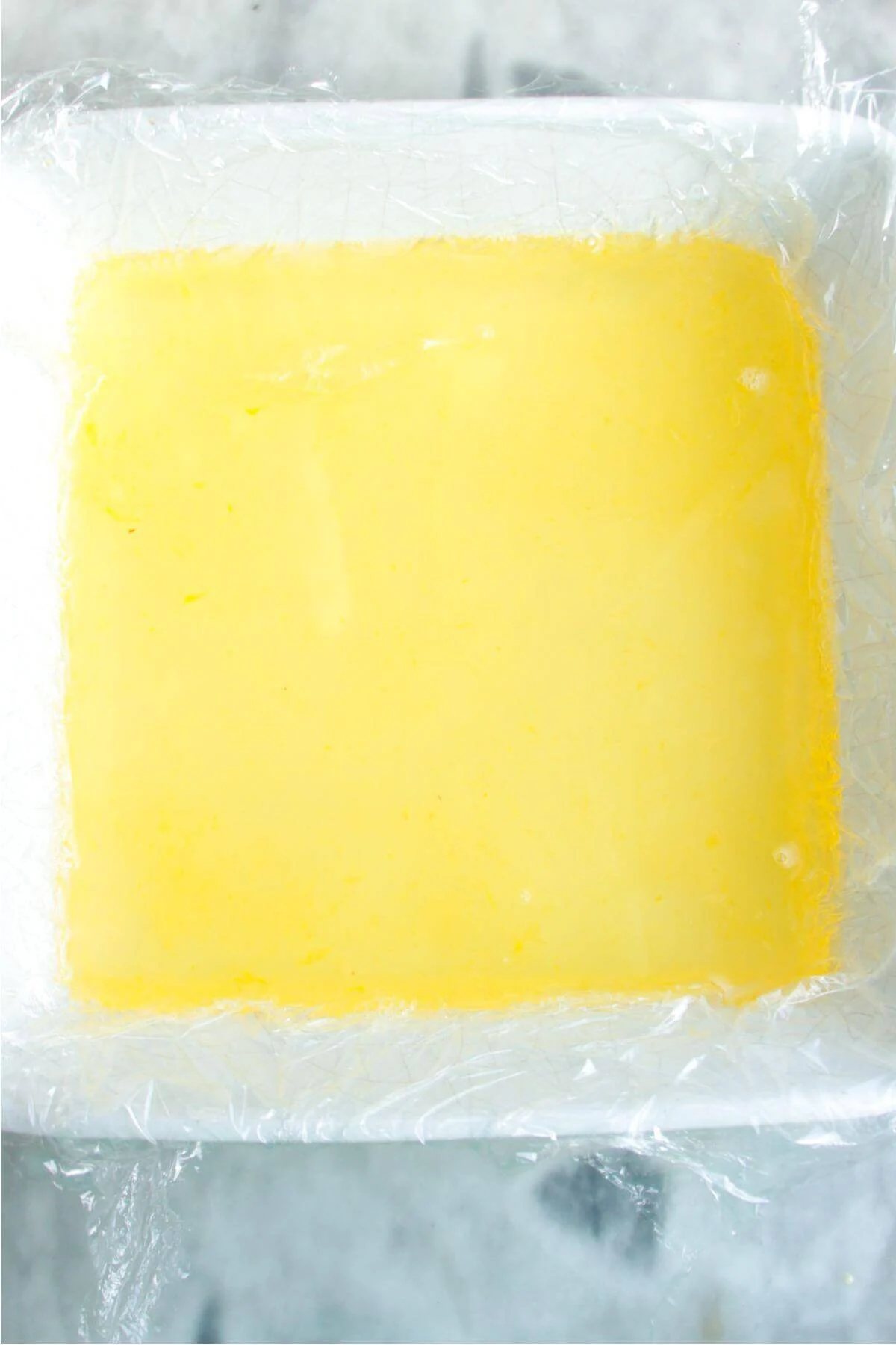 Champagne jello mixture in a white square dish.