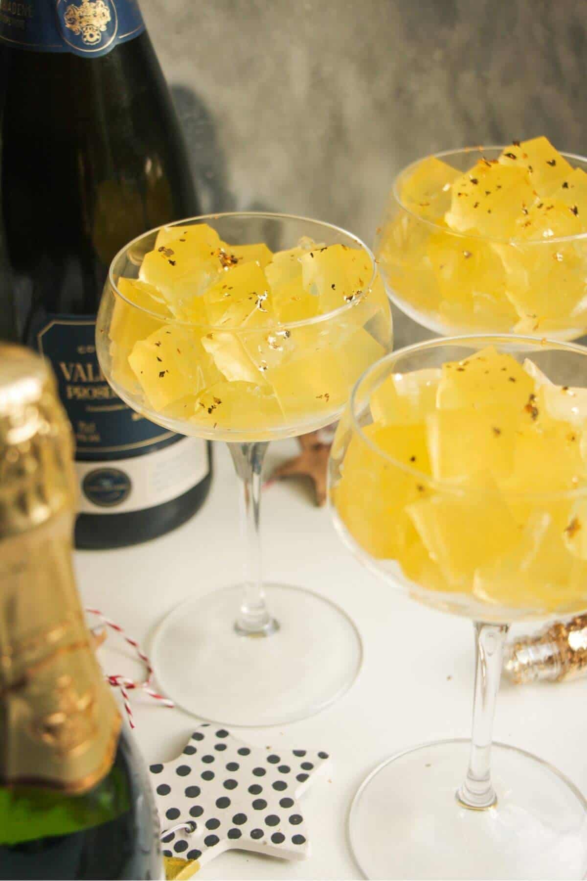 Three champagne coupes filled with jello cubes.