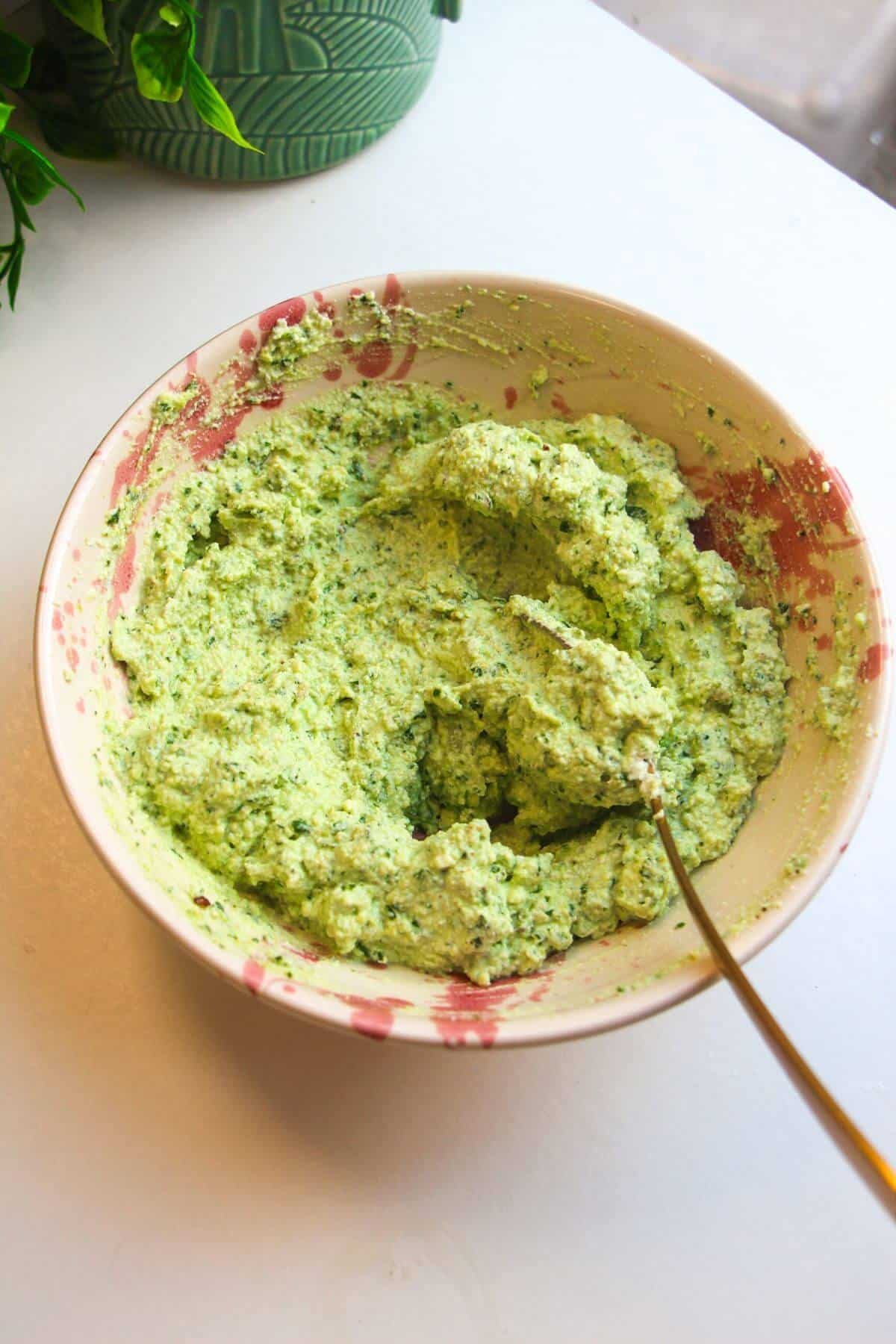 Pesto ricotta mixture in a bowl.