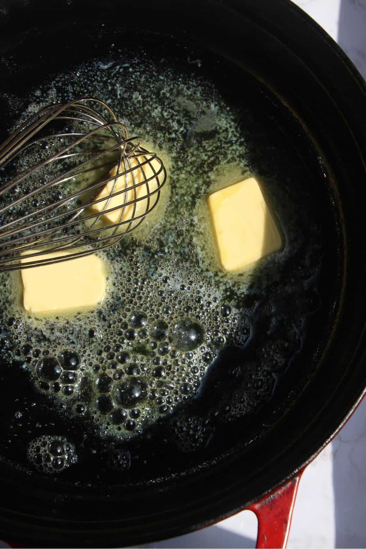 Butter melting in a large black pan.