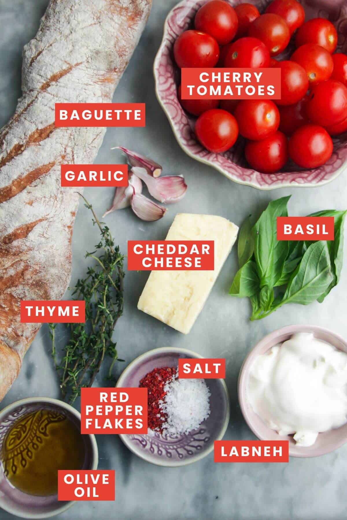 Ingredients for cheesy tomato crostini laid out and labelled.
