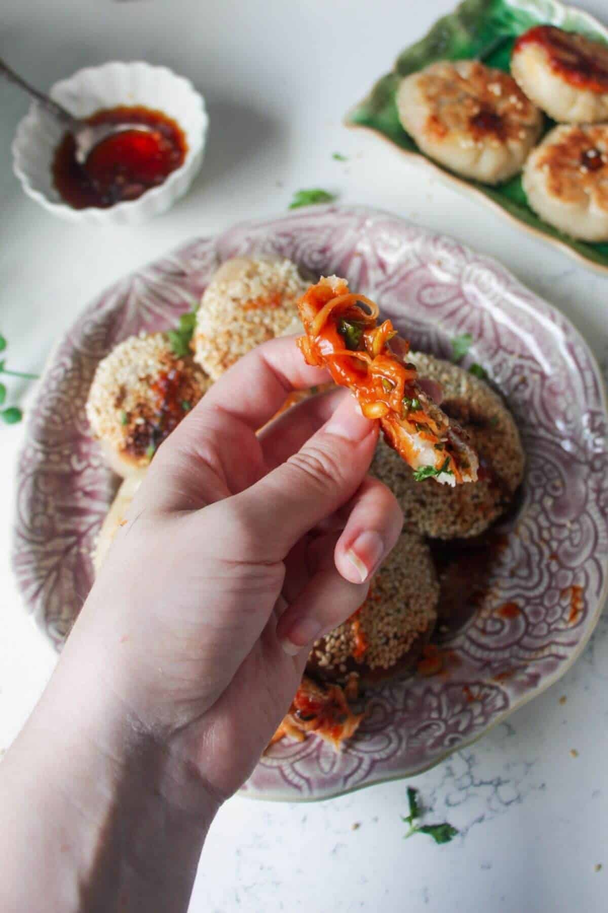 Hand holding up a torn open pizza pocket, showing gooey cheesy centre.
