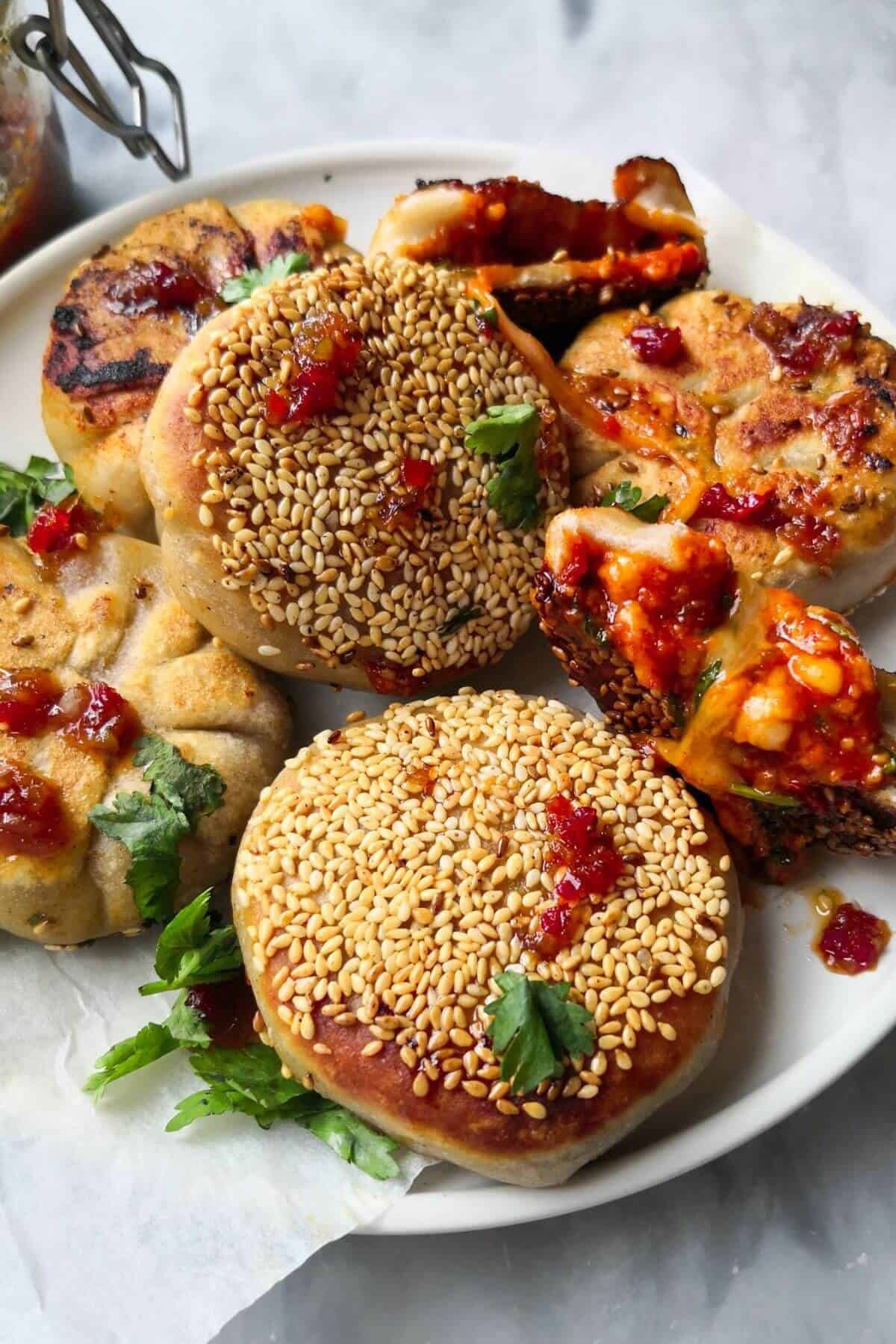 Close up of a pile of pizza pocket, with one torn open showing the cheesy gochujang centre.