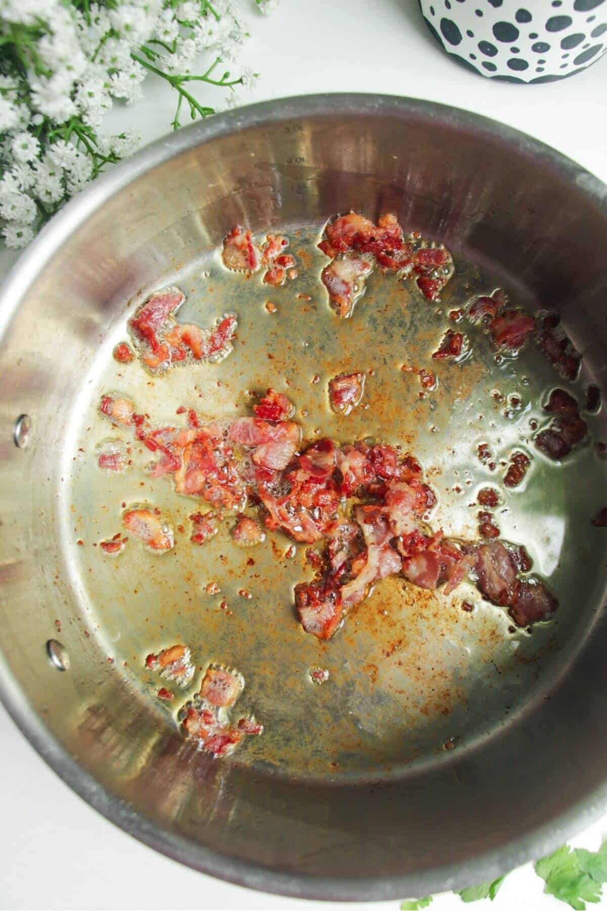 Bacon cooking in a large pan.