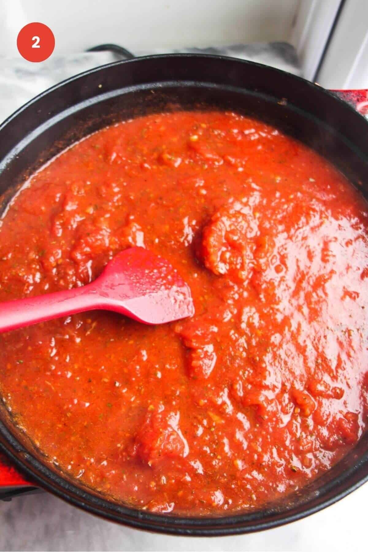 Tomato sauce simmering in a large pot.