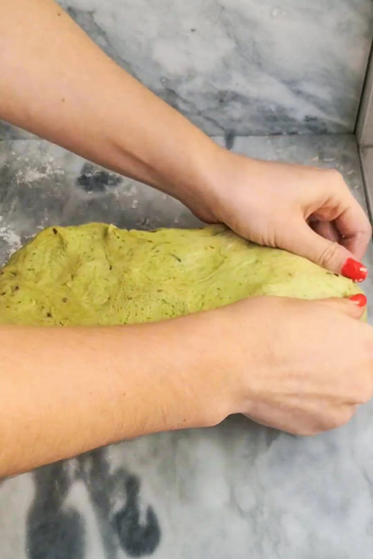 Hands sealing cheese into dough.
