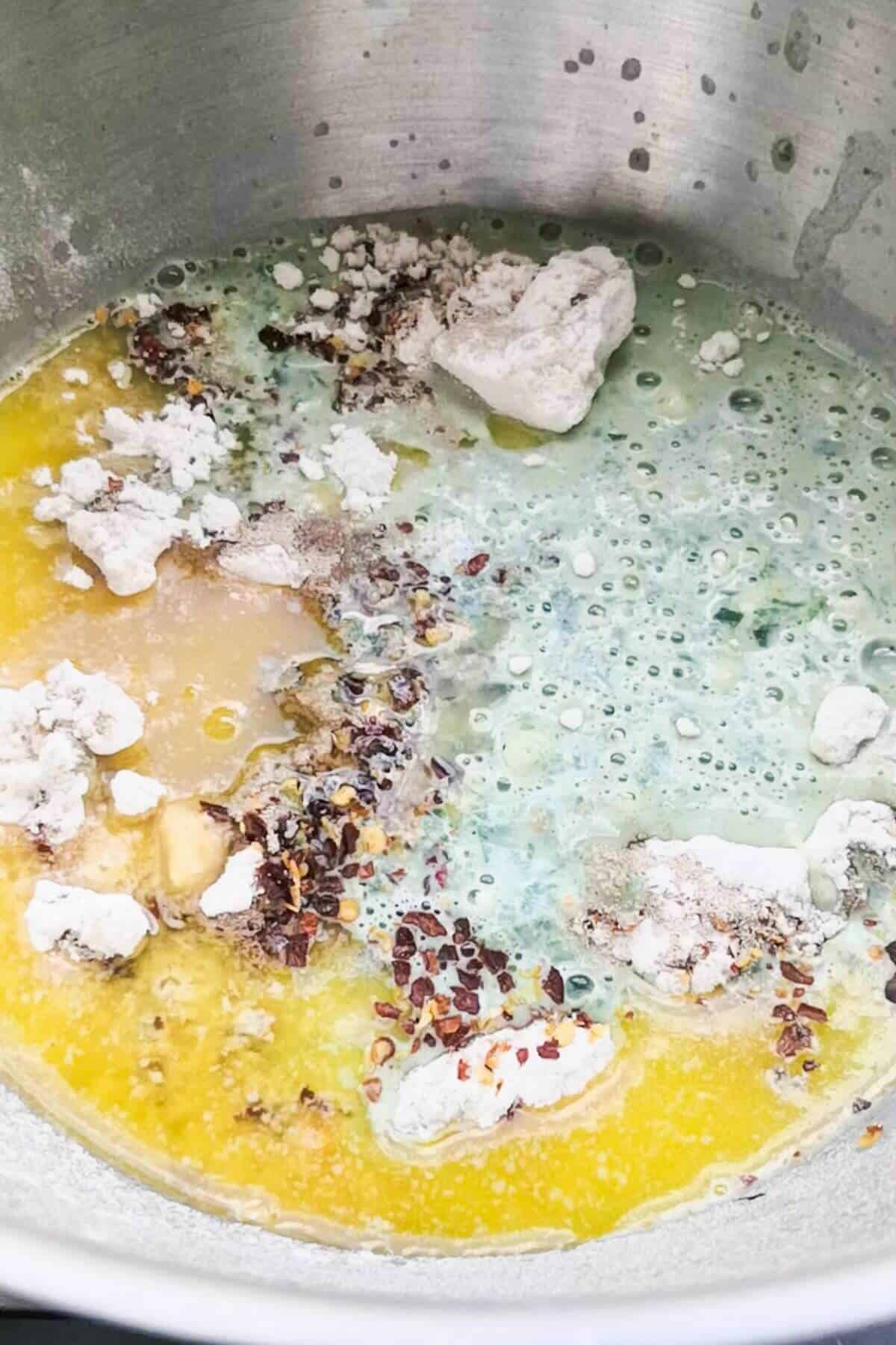 Ingredients for wild garlic hot cross buns in a silver mixing bowl.
