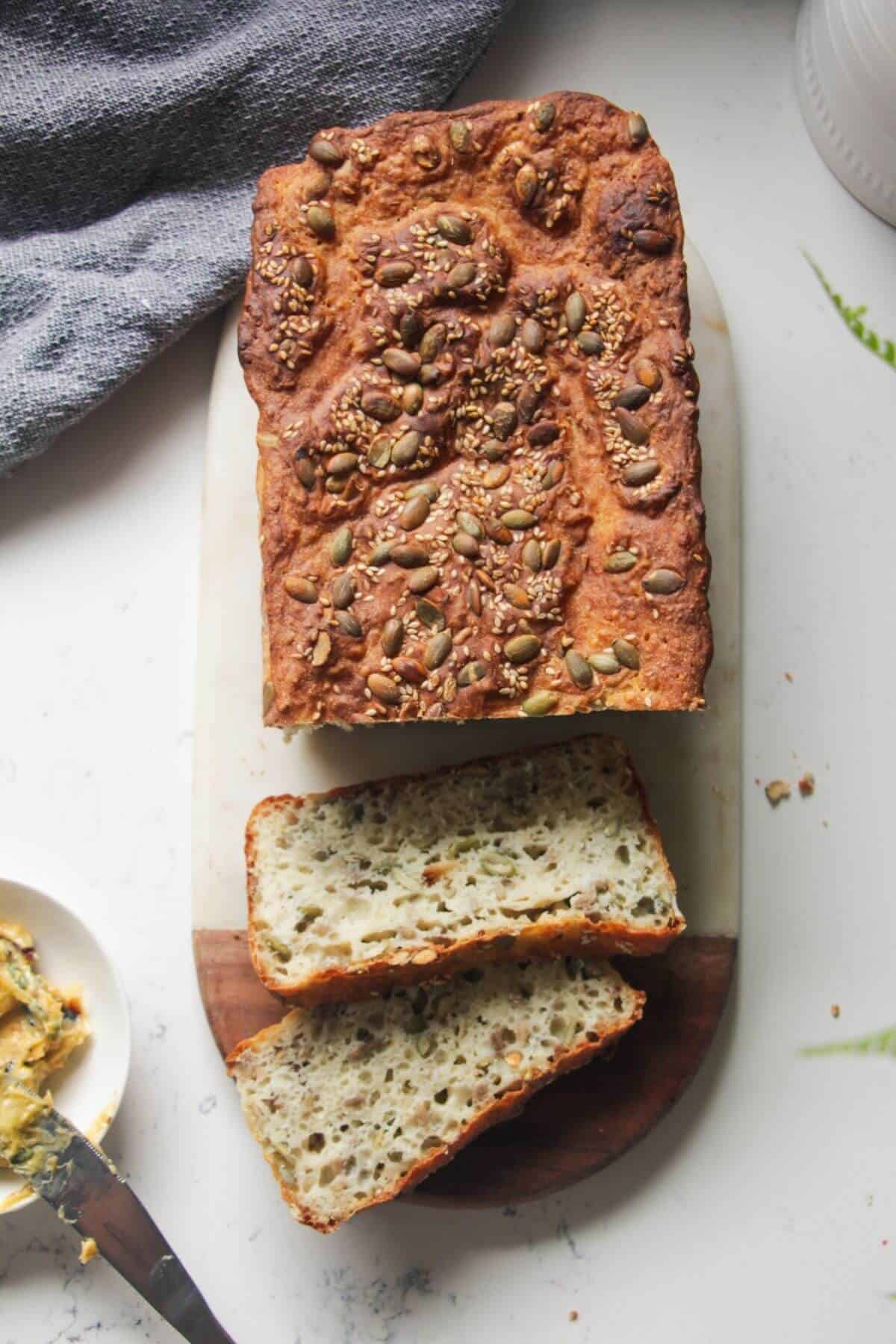 Vogel's style bread on a spoon marble and wooden board, with 2 slices taken out of it.