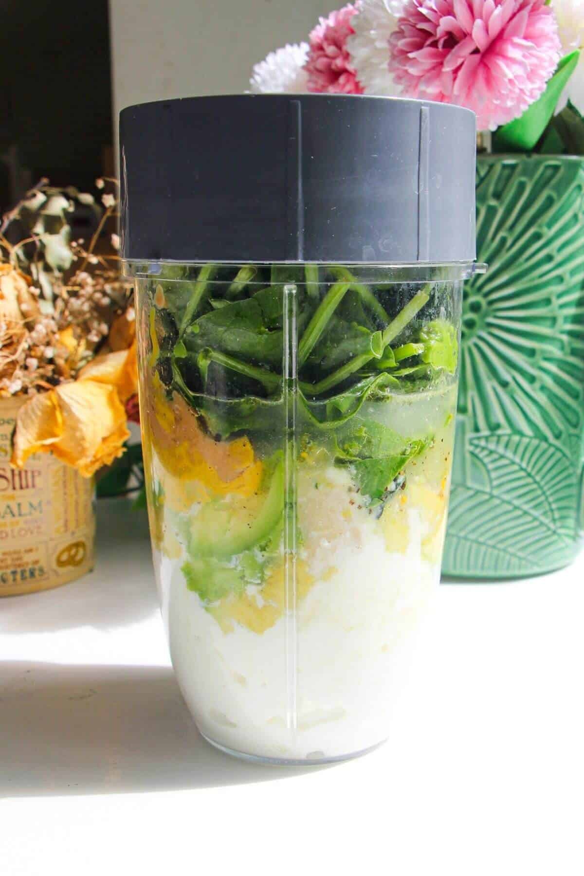 Green Caesar sauce ingredients in blender.