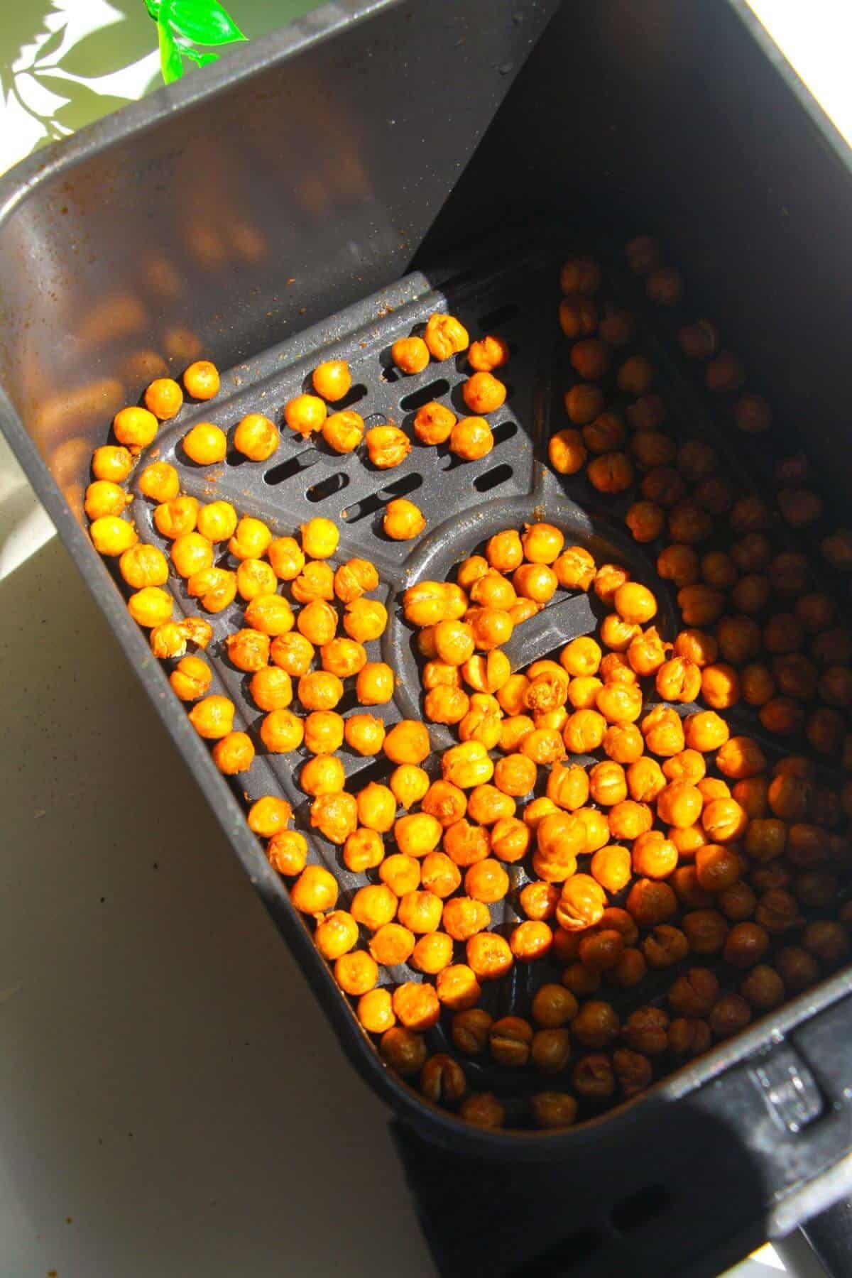 Crispy chickpeas in air fryer basket.