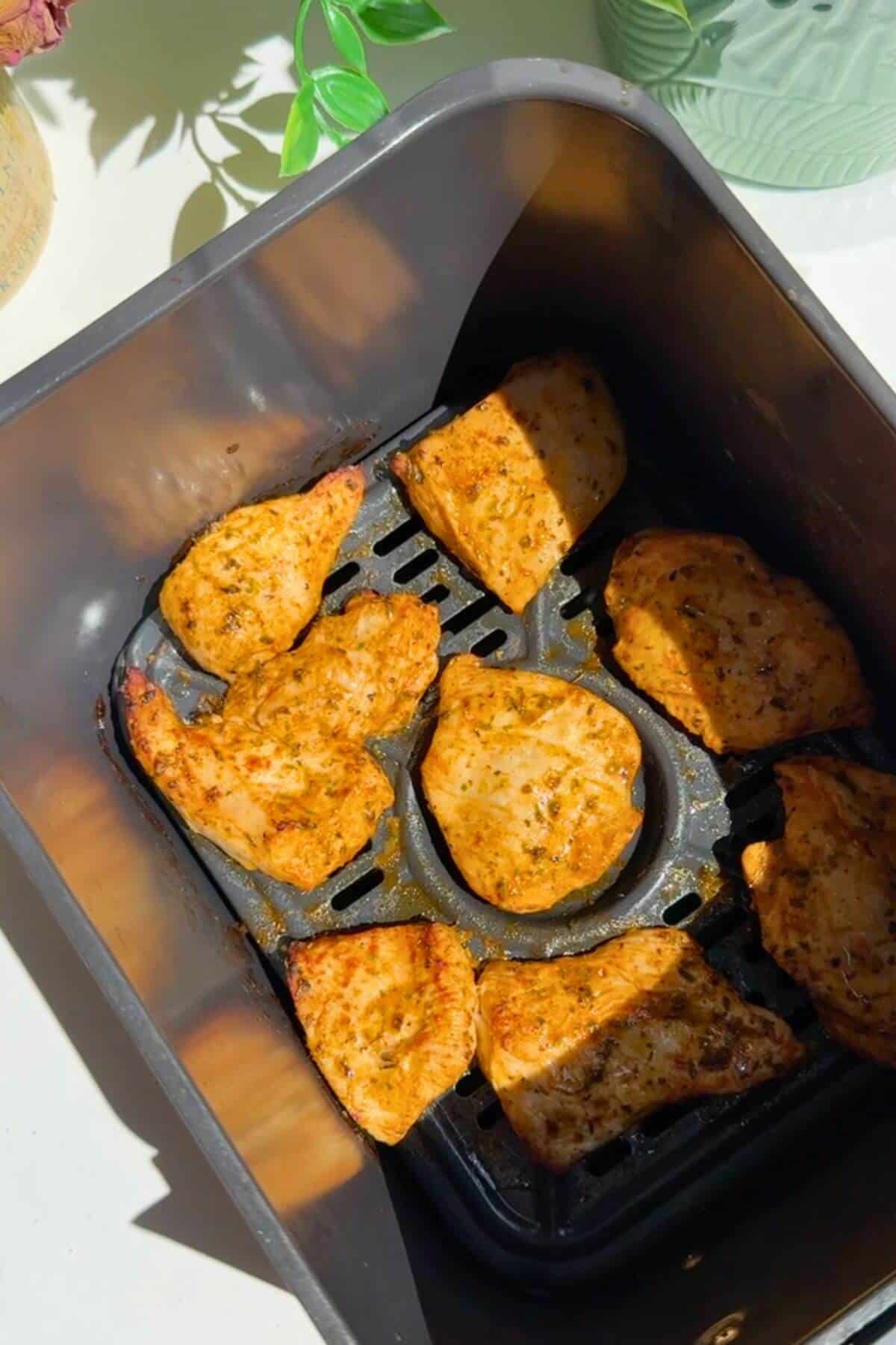 Air fried chicken breast in air fryer basket.