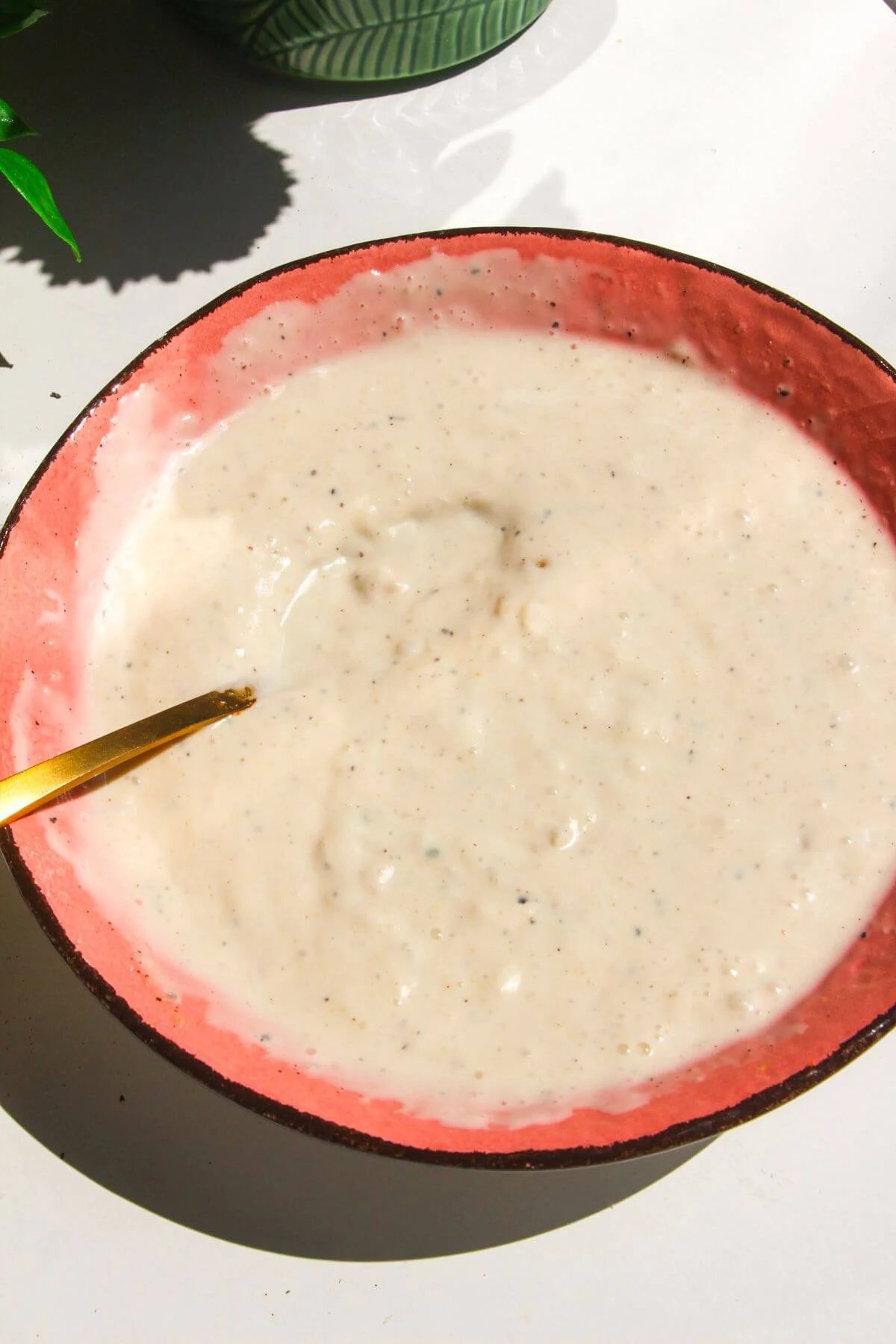 Caesar dressing mixed in a pink bowl.