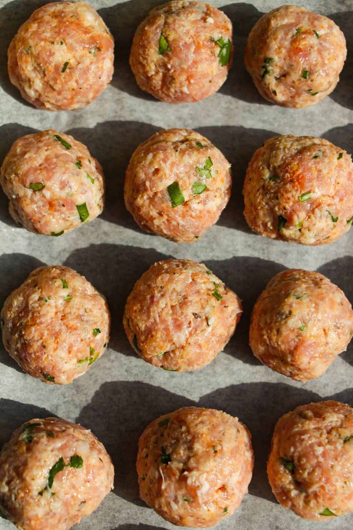 Chicken piccata meatballs on a lined oven tray.