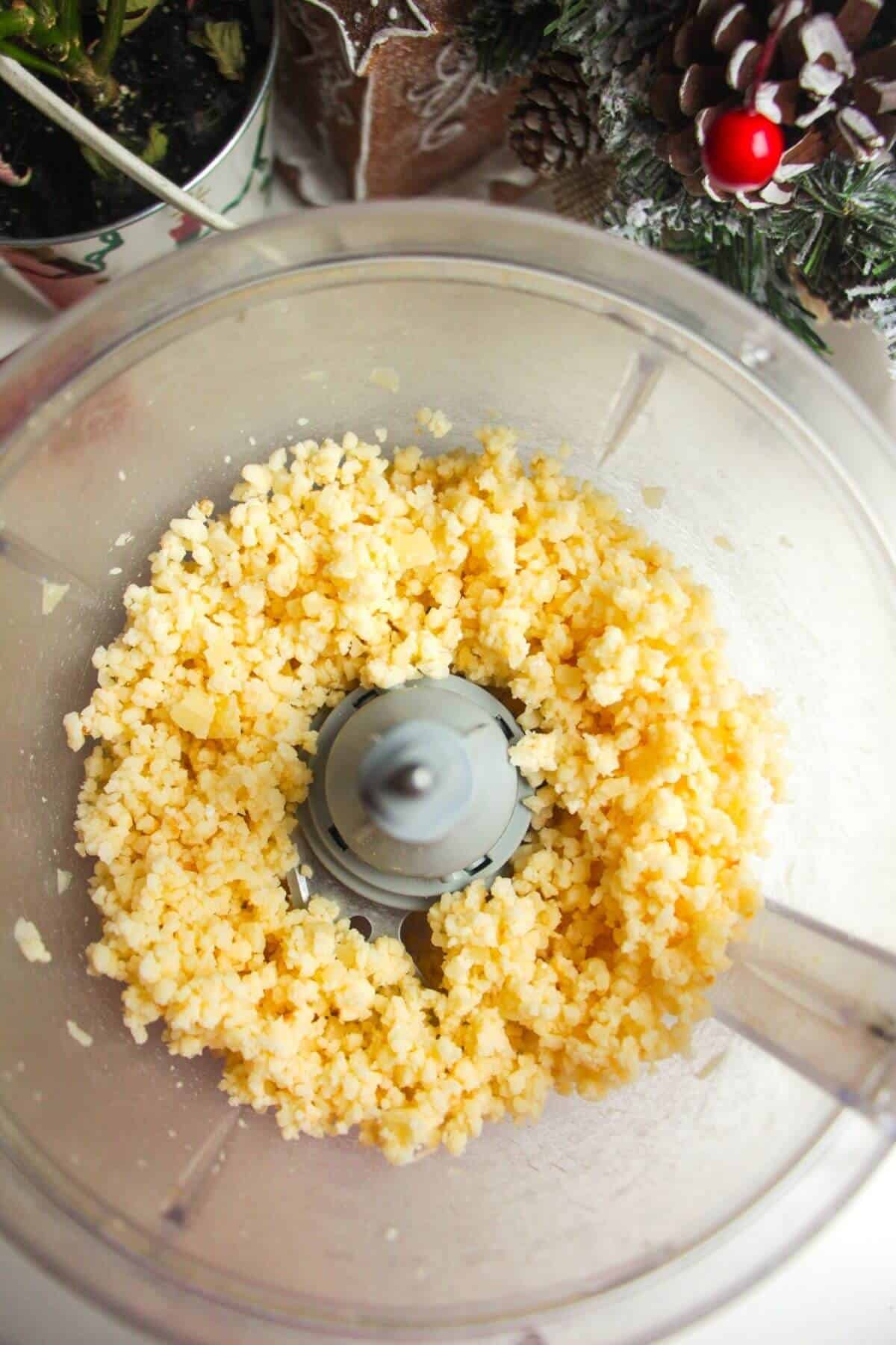 Cheese shredded in the bowl of a food processor.