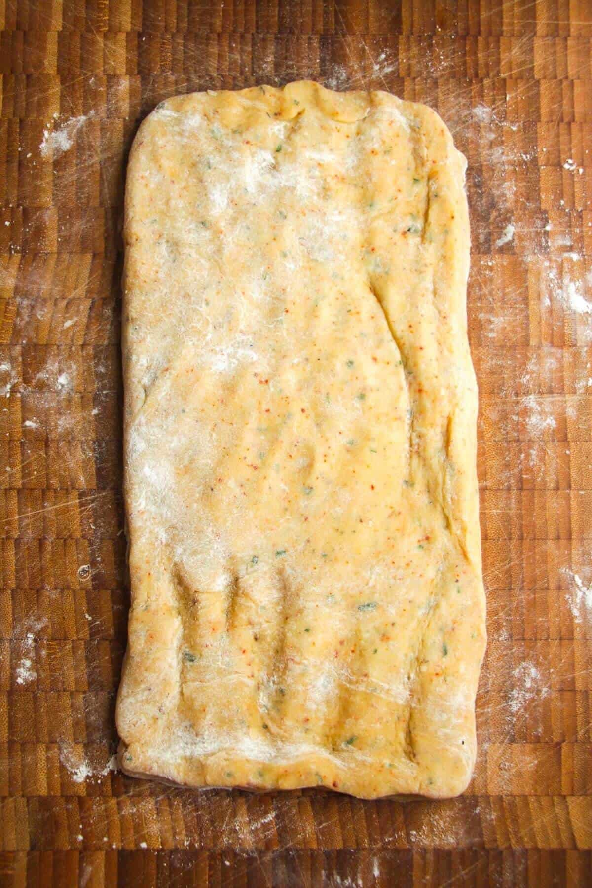 Cheese shortbread dough on a wooden board.