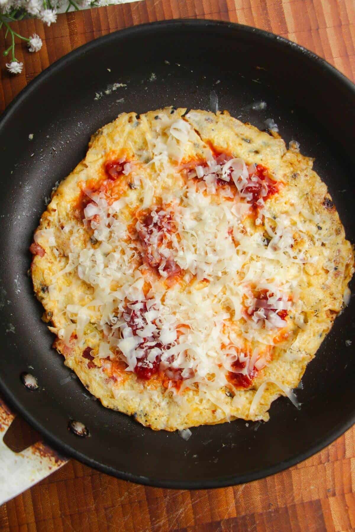 Grated cheese and sambal on top of egg on a wrap.