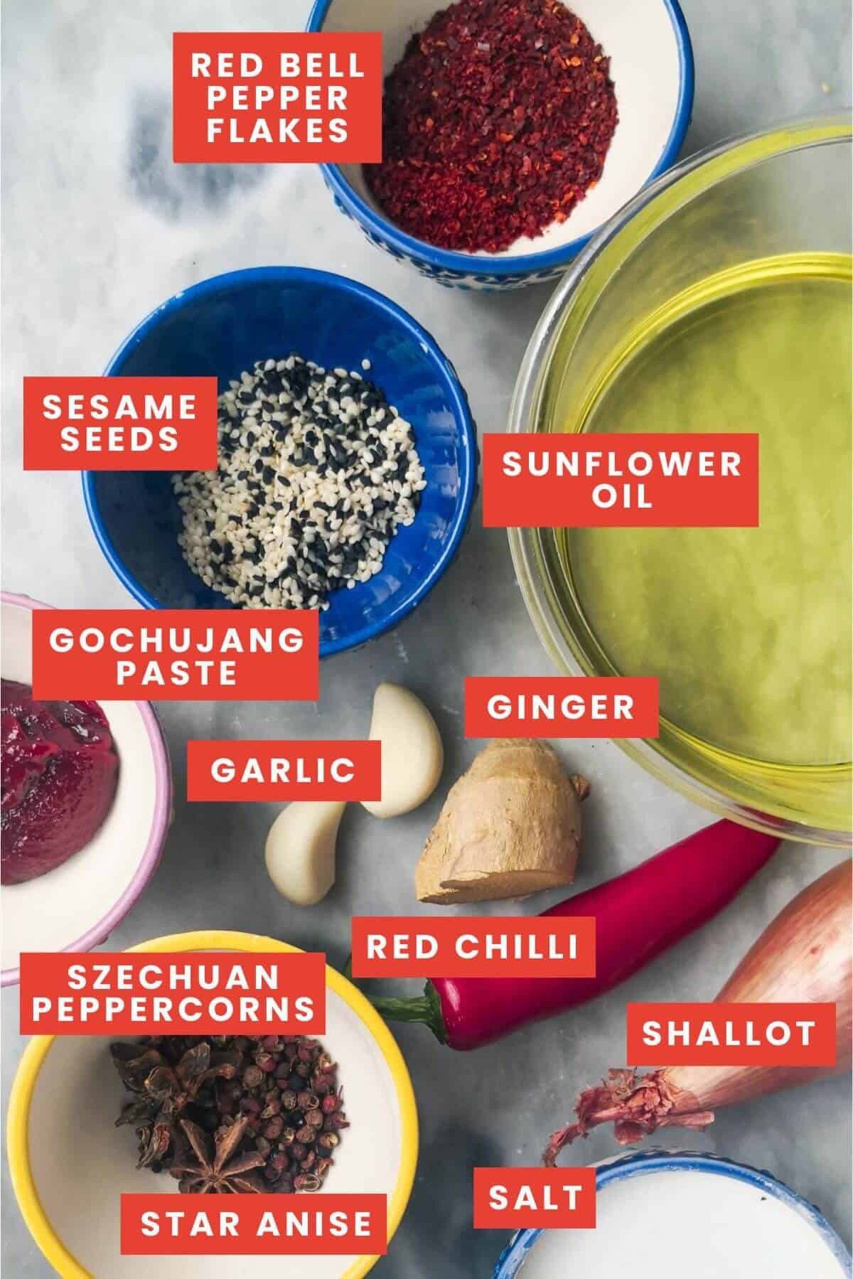 Ingredients for chilli oil laid out on a grey marble background.