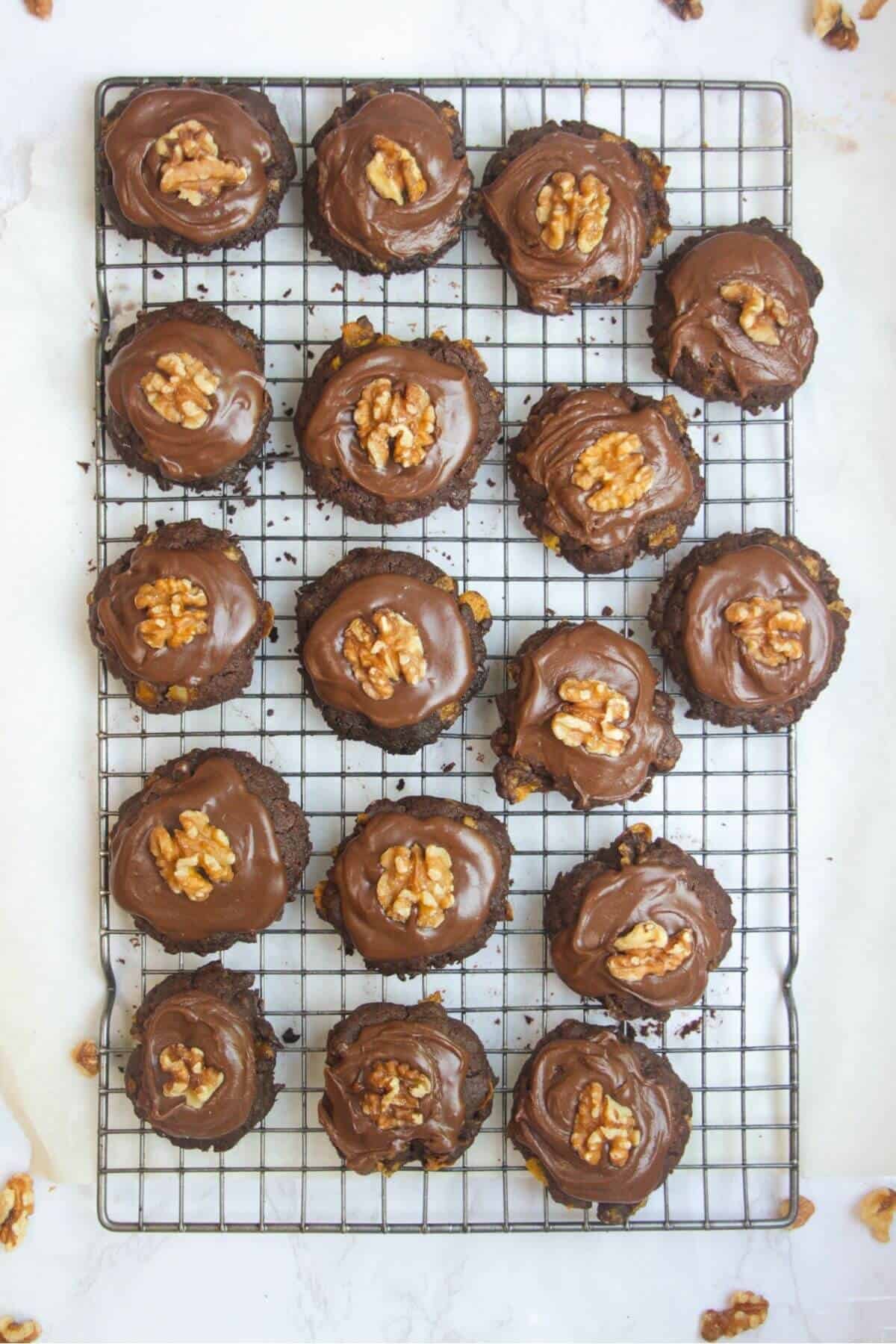 Iced chocolate Afghan biscuits on a wire rack on a white marble background.