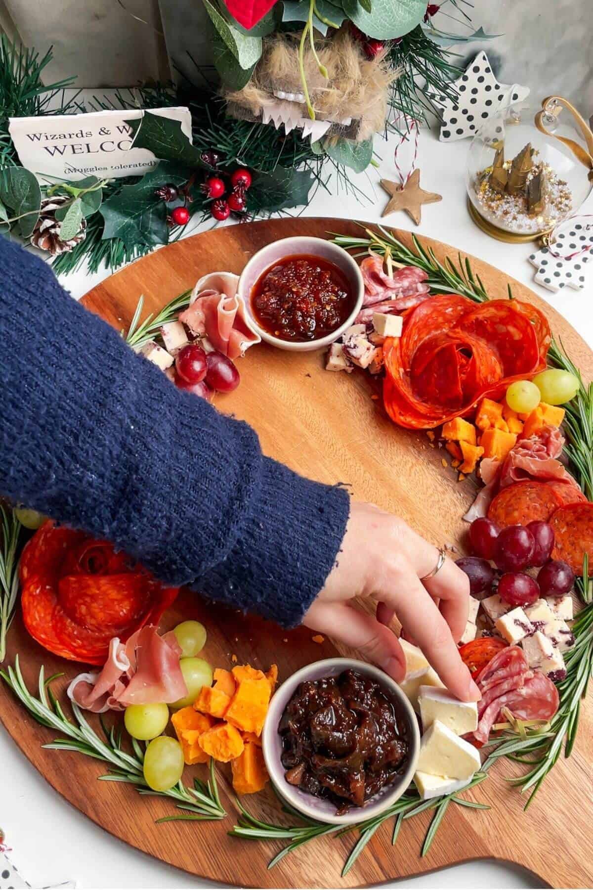 Arranging cheese and cured meats on a wooden board.