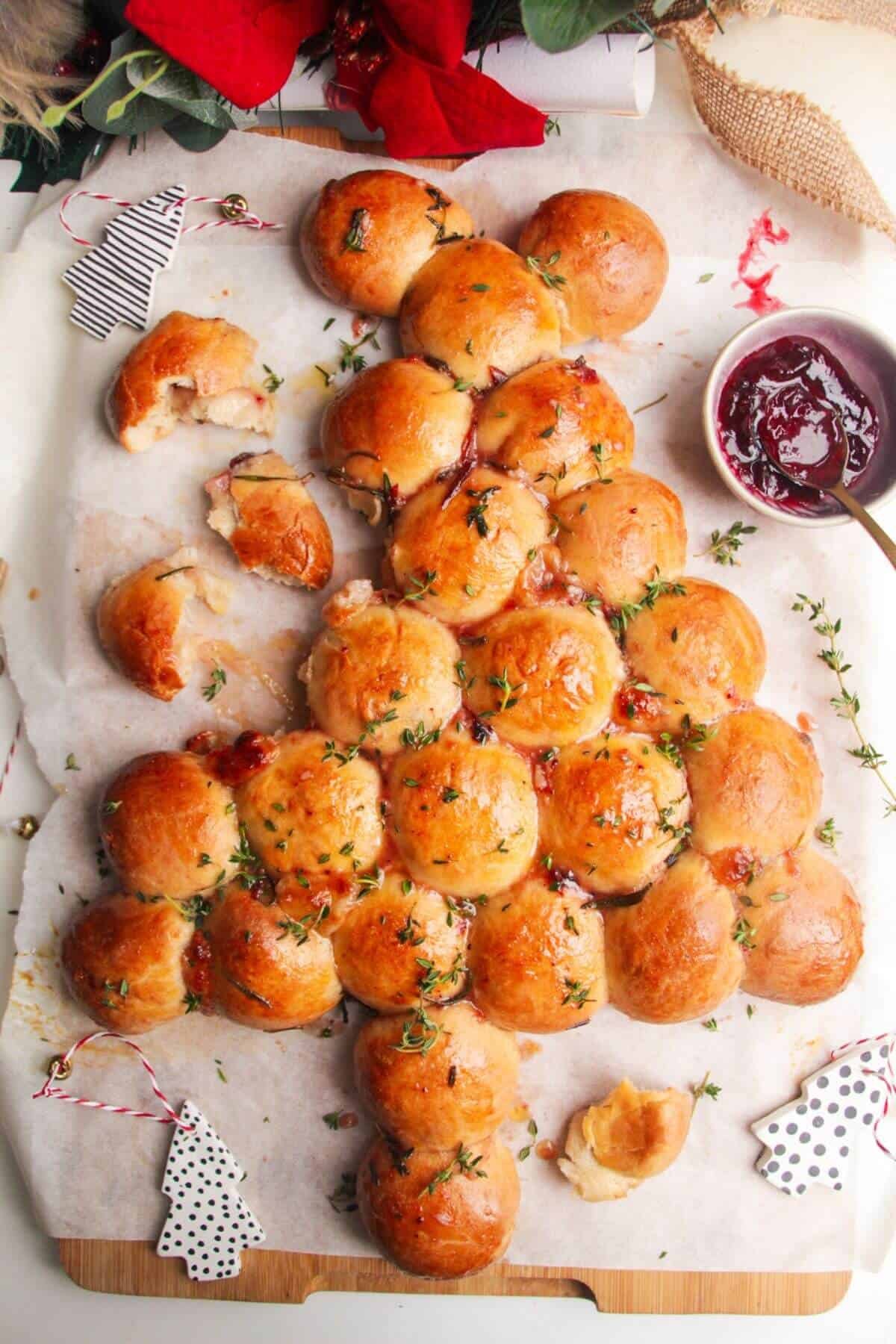 Christmas tree shaped dough balls on a lined board.