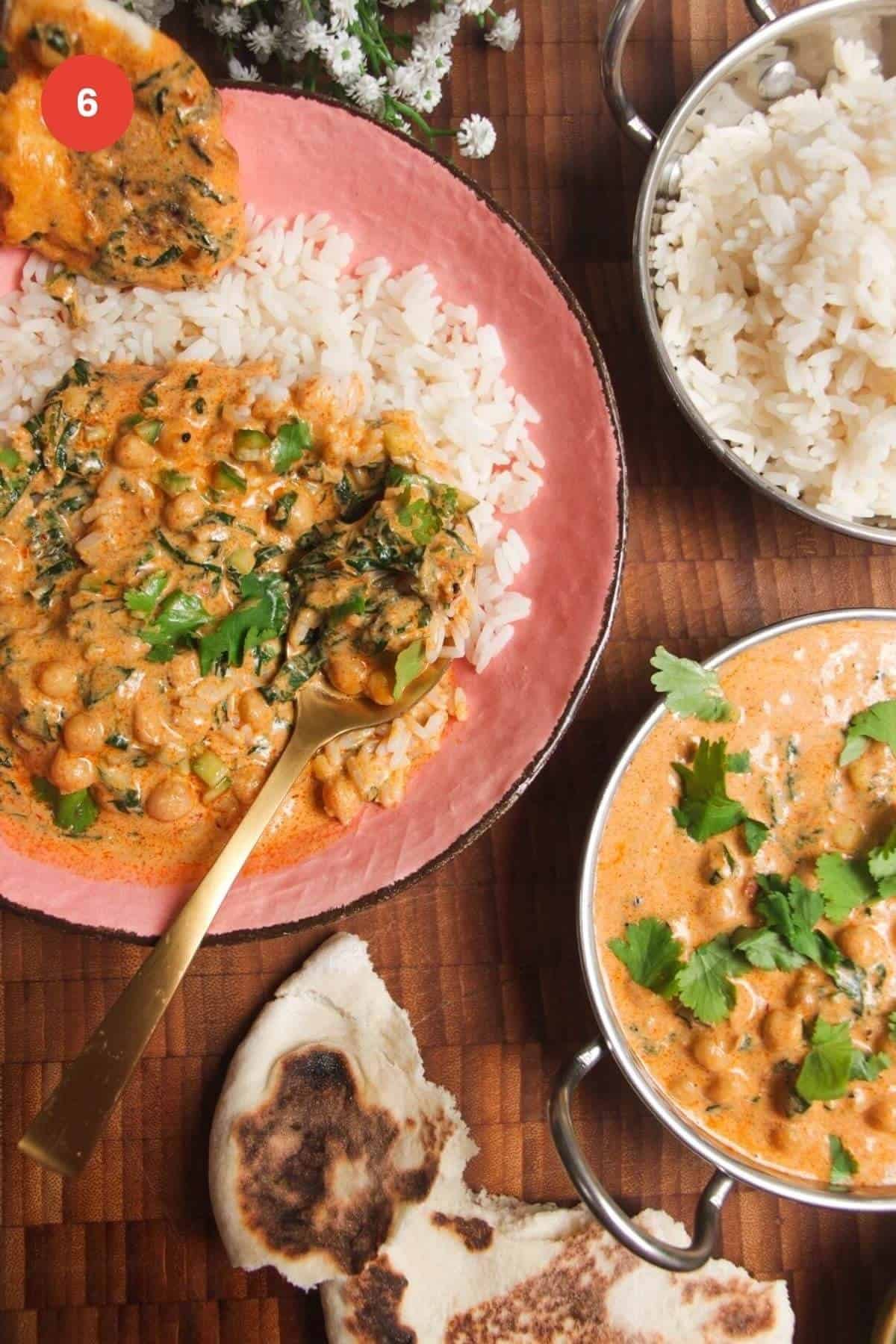 Coconut chickpea curry served over rice in a bowl with more curry on the side.