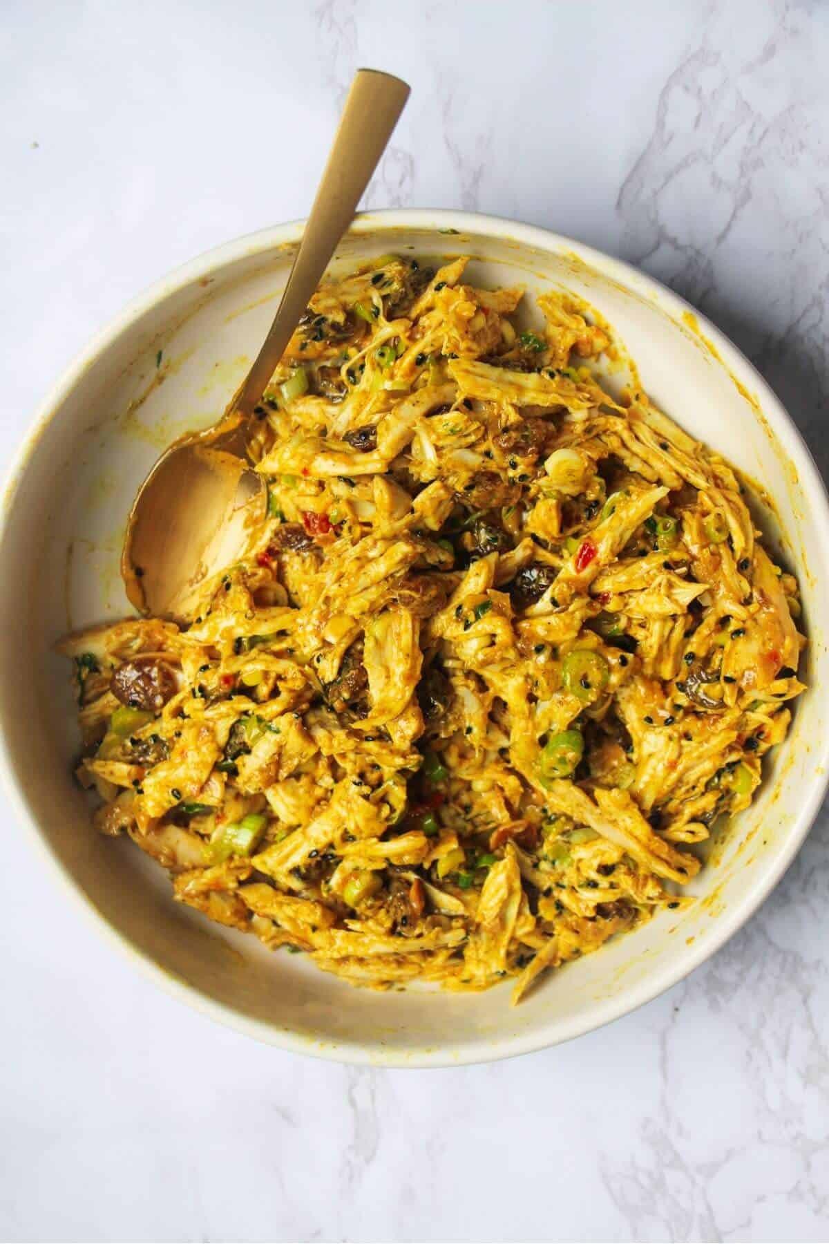 Coronation chicken mixed in a small white bowl.