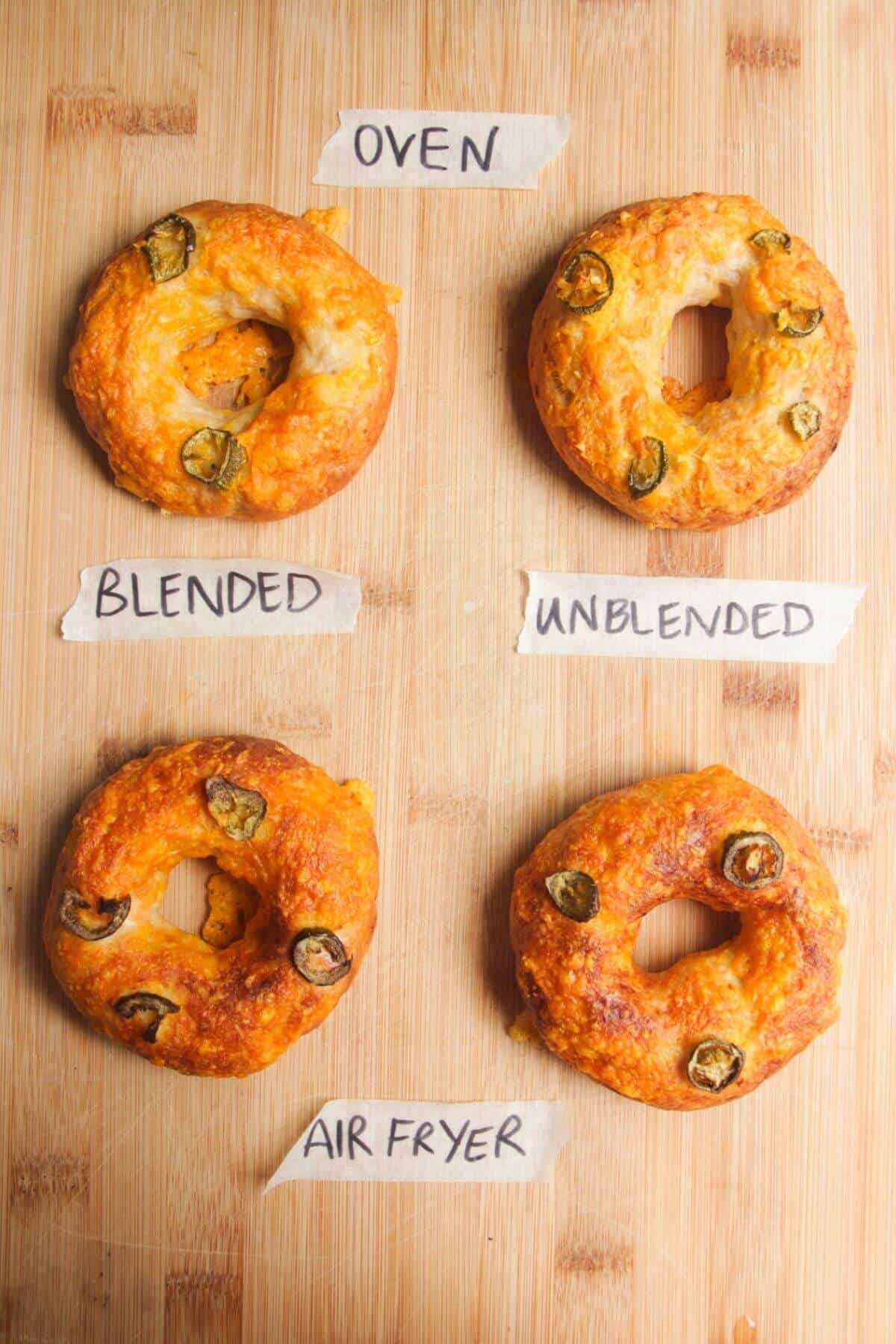 Four bagels on a wooden board.