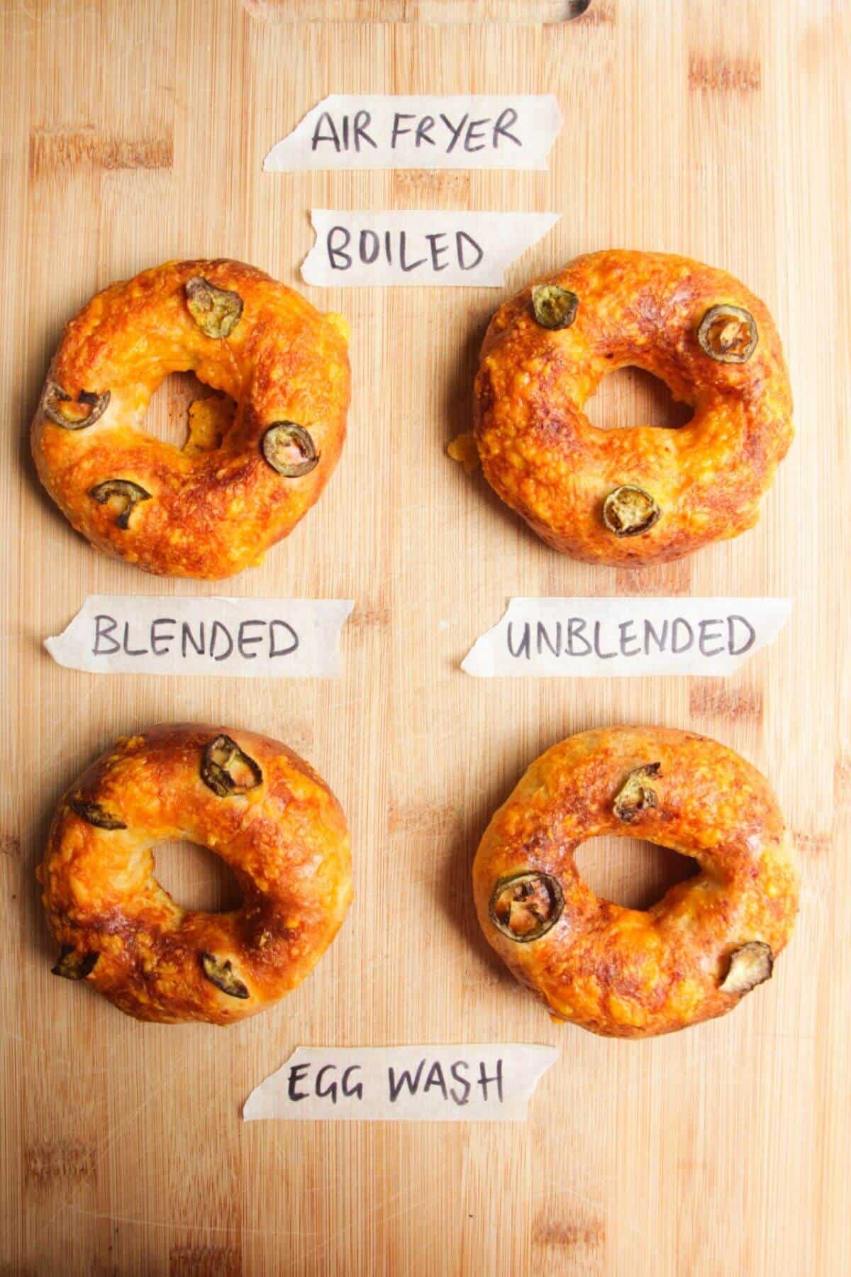 Four bagels on a wooden board.