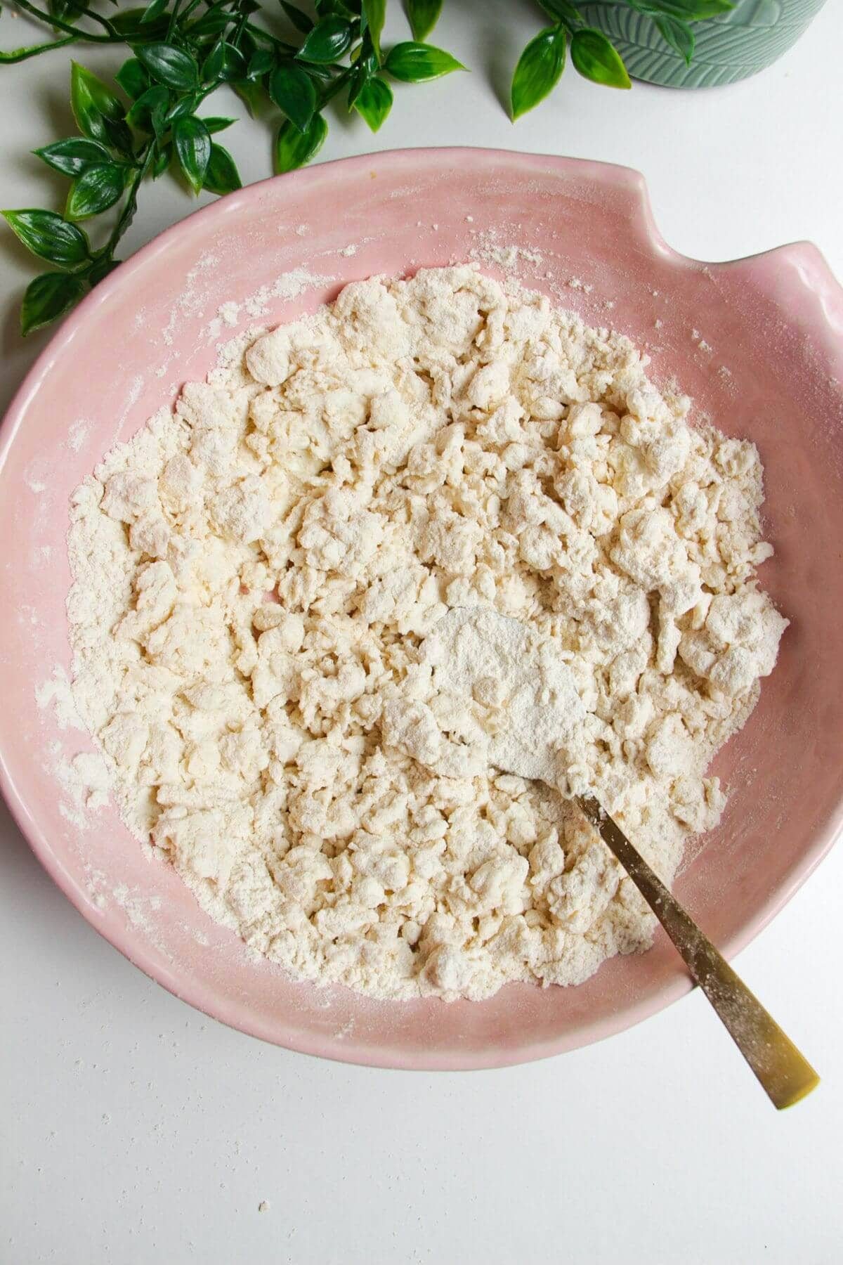 Flour and cottage cheese mixed in a pink bowl.