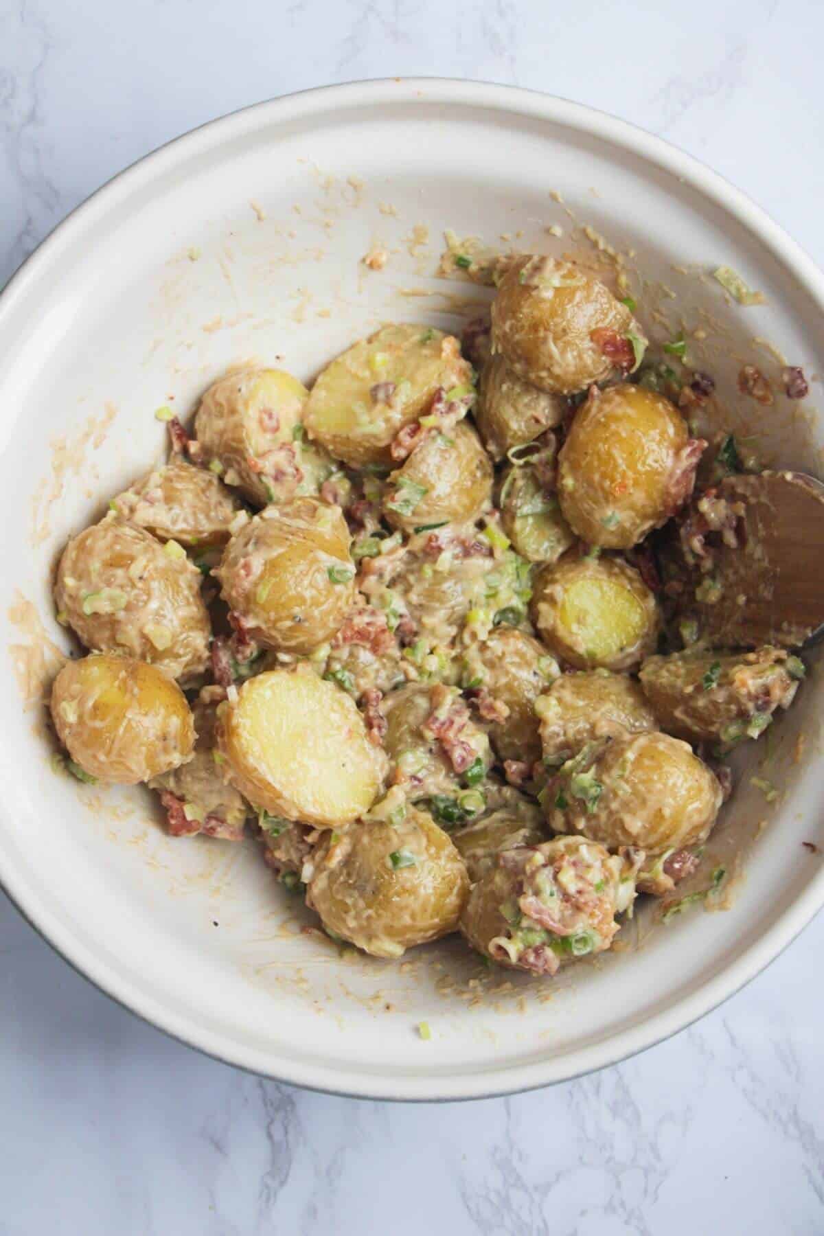 Cooked potatoes mixed with caesar dressing, bacon and scallions.